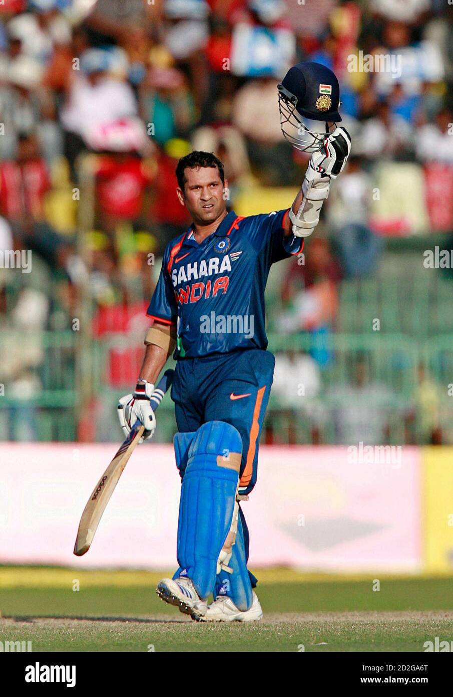 India's Sachin Tendulkar holds up his helmet to celebrate scoring a century  (100 runs) during the finals of the tri-nations one-day international  cricket series against Sri Lanka in Colombo September 14, 2009.