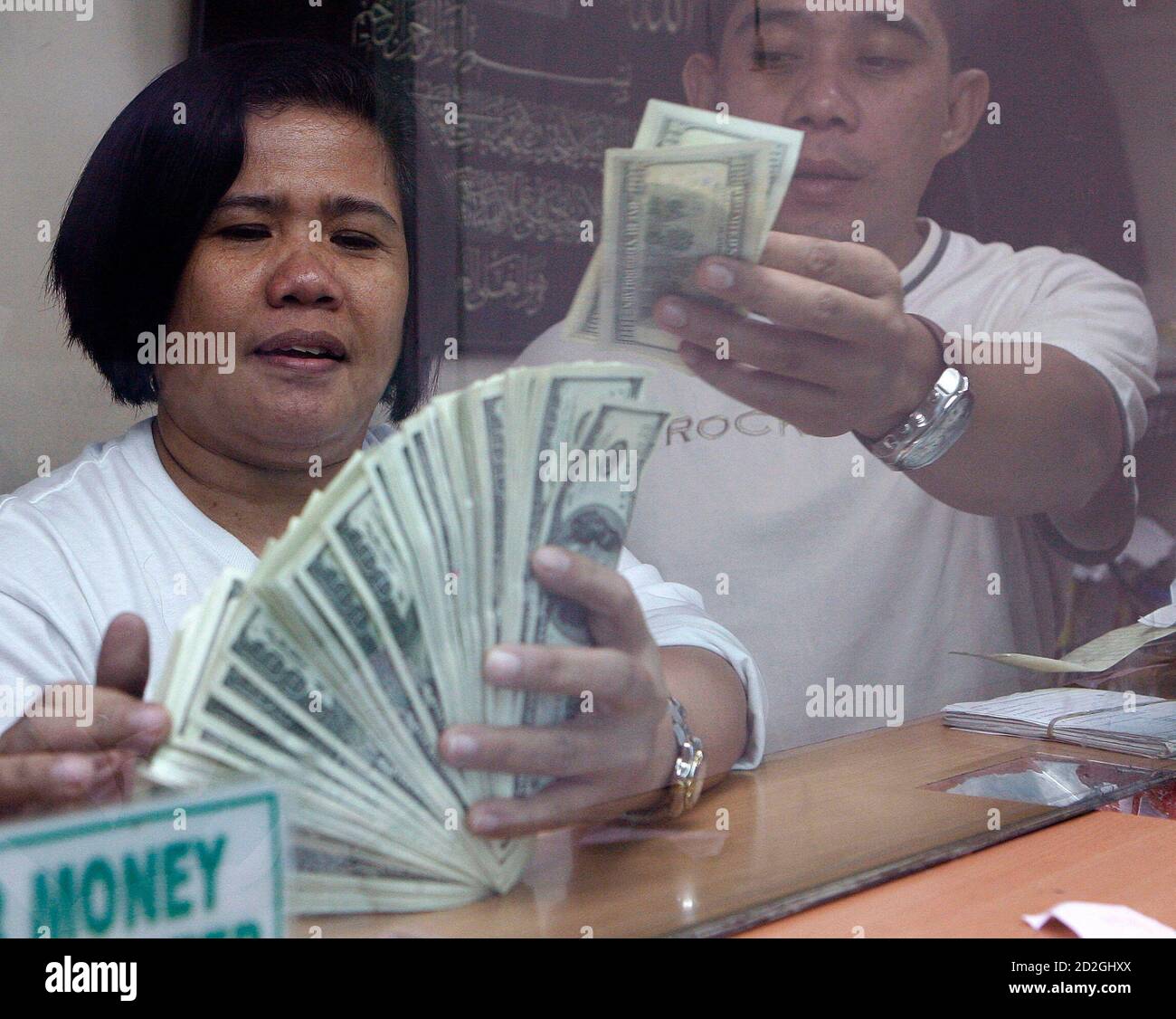 Staff at a money changer count dollar bills in Manila October 3, 2007