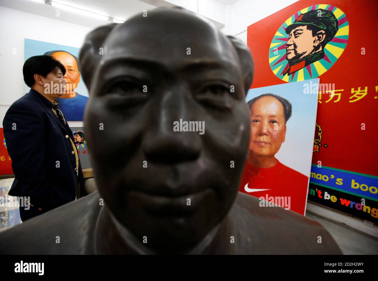 Chinese artist Zhao Jianhua, whose works include oil paintings of Mao  Zedong branded with the Nike swoosh and given the Warhol-esque pop-art  treatment, inspects his work in his studio in northeastern Beijing