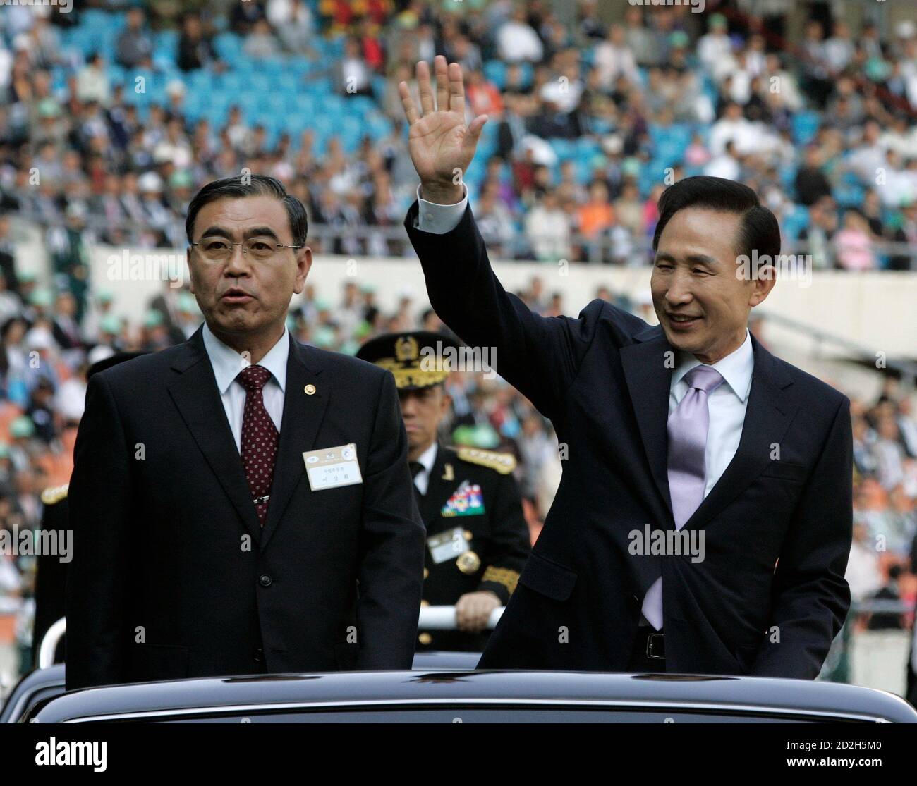South Korea's President Lee Myung-bak (R) waves to the crowd besides  Defence Minister Lee Sang-hee during the 60th anniversary of the Armed  Forces Day at Jamsil Sports Complex in Seoul October 1,