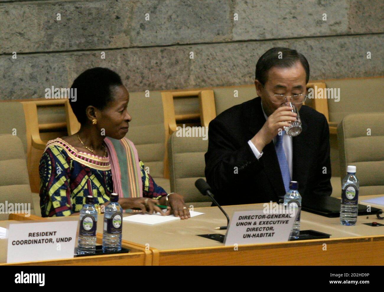 U.N. Secretary-General Ban Ki-Moon (R) takes a drink as U.N. Human Settlements Programme Executive Director Anna Tibaijuka looks on during a meeting with U.N. staff at the Gigiri office in Nairobi January 31, 2007. REUTERS/Thomas Mukoya (KENYA) Stock Photo