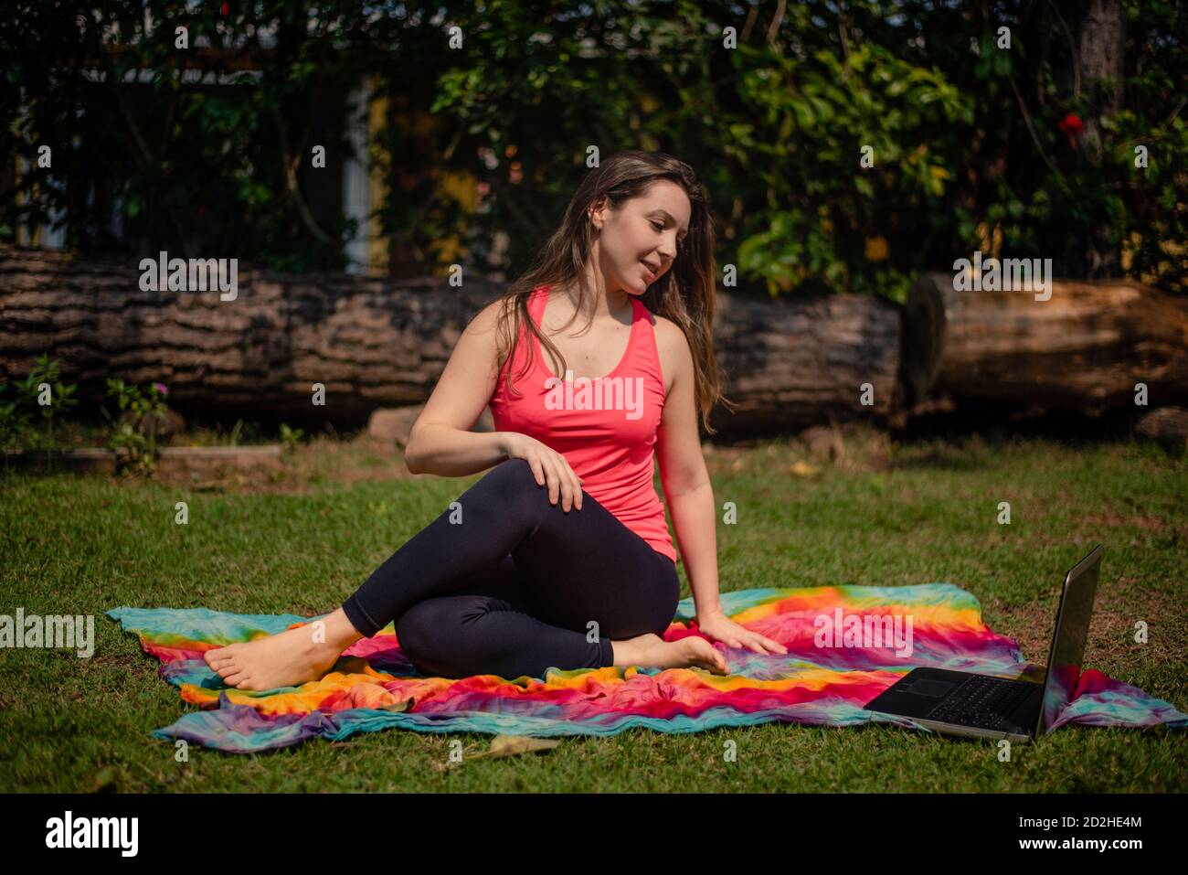 Woman practicing pilates lesson online in garden Stock Photo