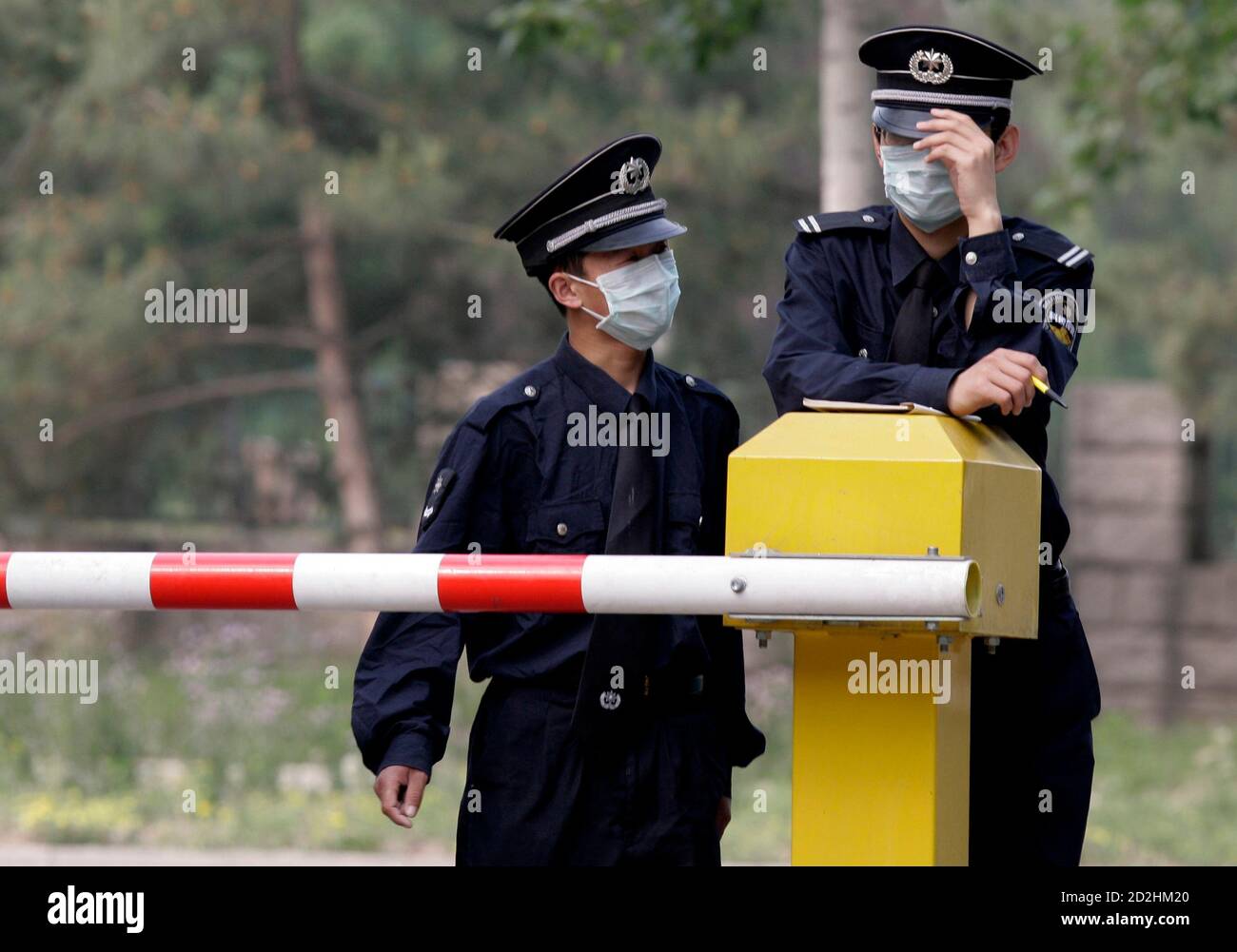 Security guards wearing surgical masks chat at the entrance of sealed-off Guo Men Hotel, where Mexican nationals are being held under quarantine, in Beijing, May 5, 2009. Mexico announced plans on Monday to send a plane to retrieve dozens of its nationals confined across China, which quarantined them as a protective measure against a deadly new strain of flu. REUTERS/Jason Lee (CHINA HEALTH) Stock Photo
