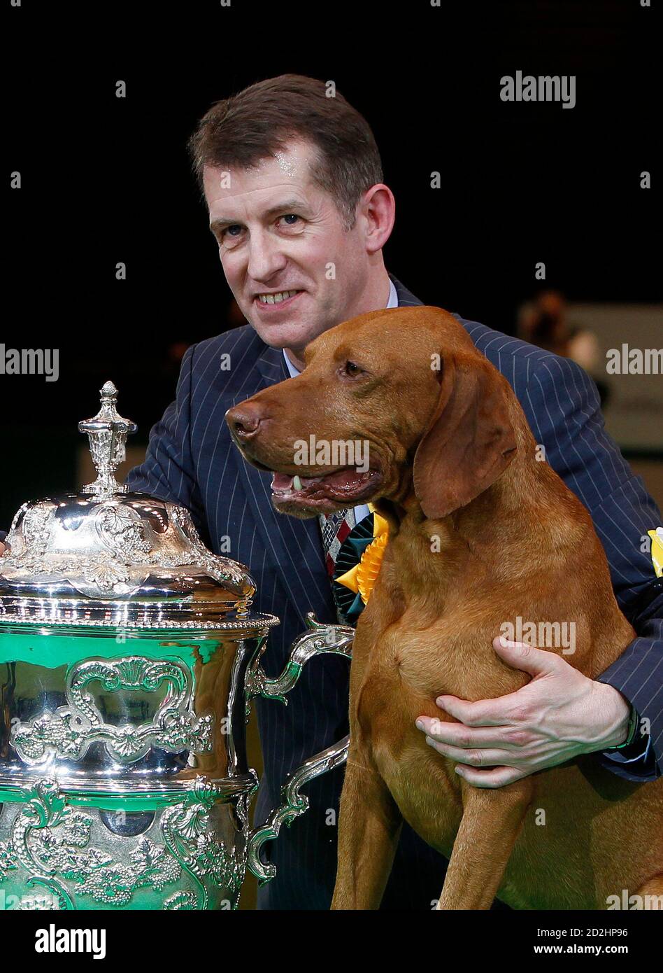 Crufts Best in Show winner Yogi poses next to the trophy with handler John  Thirwell in Birmingham, central England, March 14, 2010. REUTERS/Eddie  Keogh (BRITAIN - Tags: SOCIETY ANIMALS Stock Photo - Alamy