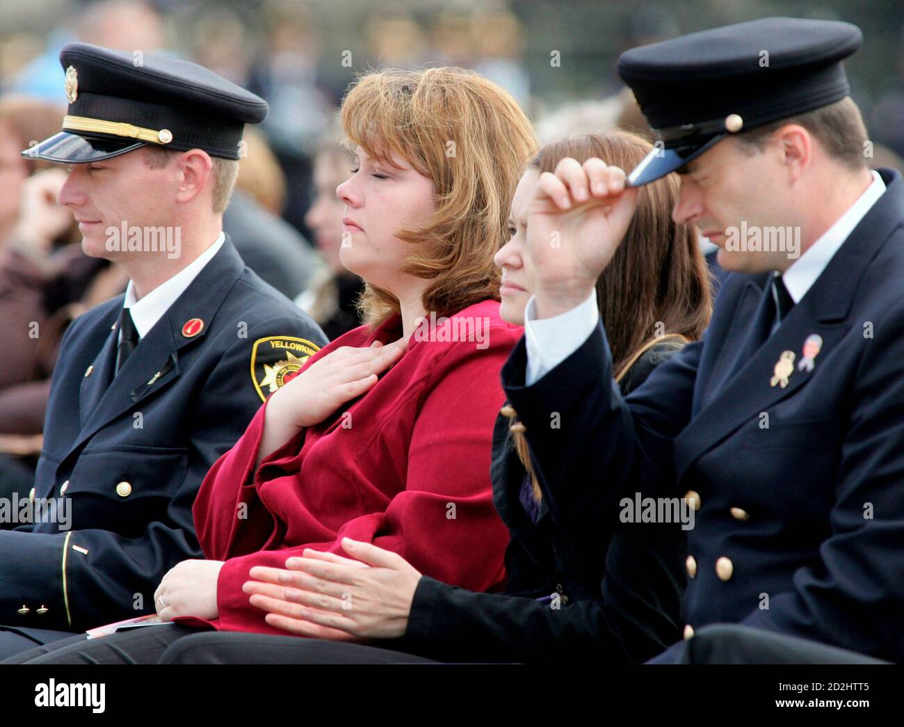 The wife of fallen firefighter Lieutenant Cyril Fyfe, Andrea Loomis (2nd L), reacts during the Canadian Fallen Firefighters memorial service on Parliament Hill in Ottawa, September 10, 2006. Fyfe's daughter, Jolene Fyfe (2nd R), is seated beside her.     REUTERS/Chris Wattie  (CANADA) Stock Photo