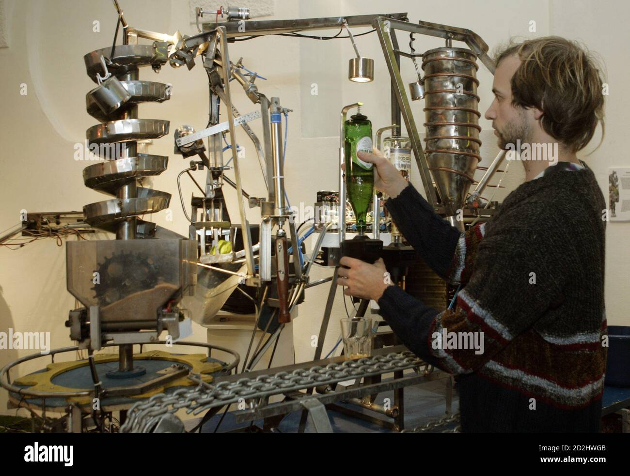 Artist Robert Martin of Germany adjusts some bottles on his "Robomoji", one of around 30 robots at Vienna's annual Roboexotica, December 7, 2006, which showcases how home-built machines deal with the modern pastime of hanging out in bars. Picture taken December 7, 2006. TO ACCOMPANY STORY AUSTRIA-ROBOTS/ REUTERS/Herwig Prammer (AUSTRIA) Stock Photo