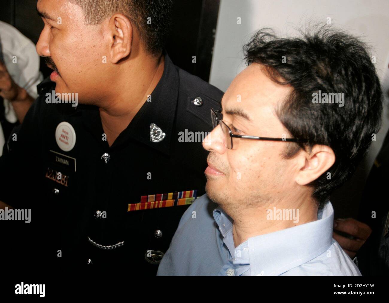 Abdul Razak Abdullah Baginda is escorted by police as he arrives at a courthouse in Shah Alam outside Kuala Lumpur June 4, 2007. Malaysia postponed on Monday the trial of a prominent political analyst accused of involvement in the murder of a Mongolian model, Altantuya Shaariibuu, feeding months of frenzied speculation about government links to the case.   REUTERS/Zainal Abd Halim (MALAYSIA) Stock Photo