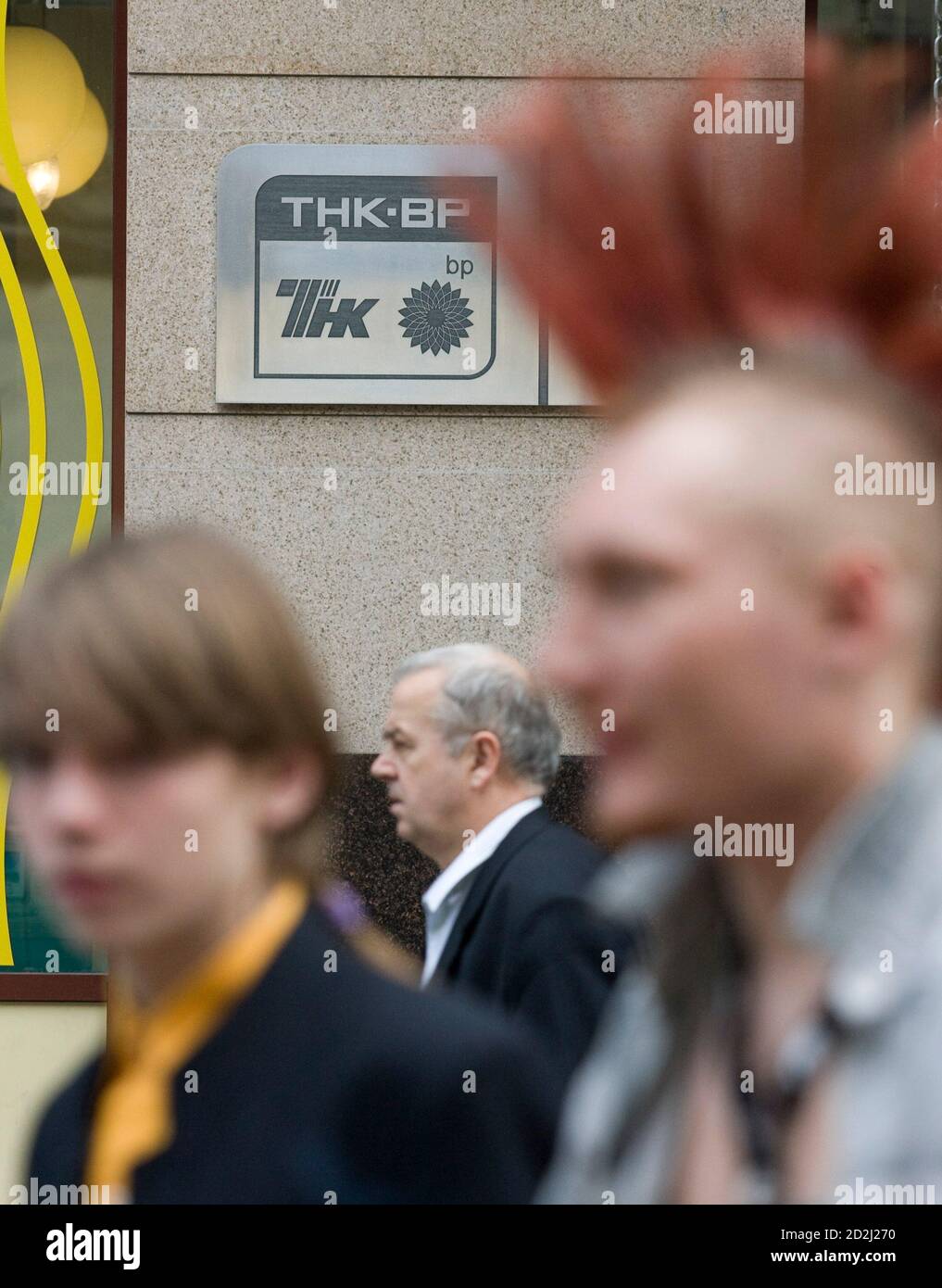 People walk past a plaque of the oil firm TNK-BP at its headquarters in Moscow June 11, 2008. The four billionaire Russian shareholders in BP's troubled Russian joint venture, TNK-BP, said on Wednesday they would sue BP in a Stockholm court and launch separate legal actions in Moscow to strip BP-nominated TNK-BP directors of their powers.   REUTERS/Sergei Karpukhin  (RUSSIA) Stock Photo
