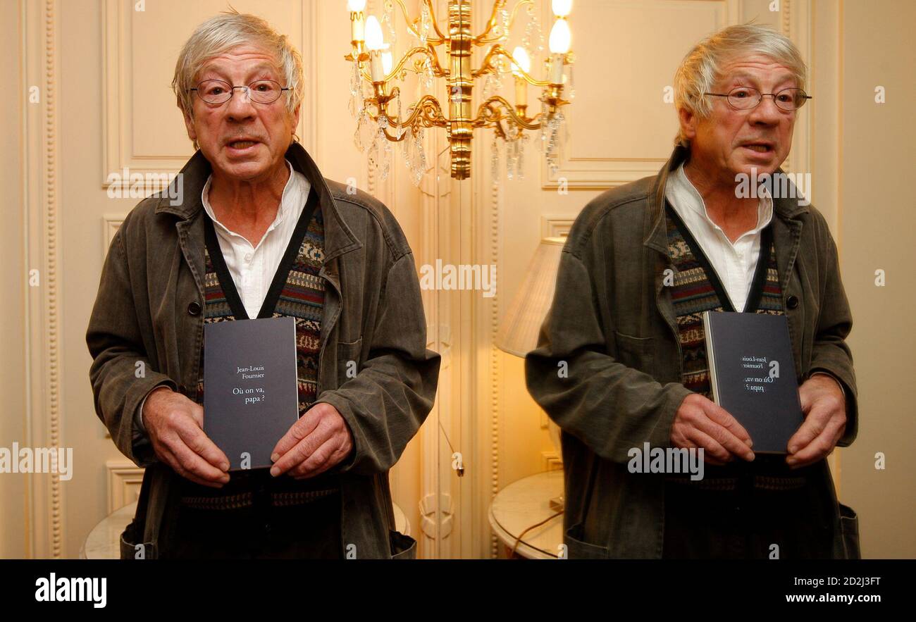 French writer Jean-Louis Fournier (L), stands beside a mirror in a Paris  Hotel, as he holds up his book "Ou on va papa ?" after he won the French  Femina prize November