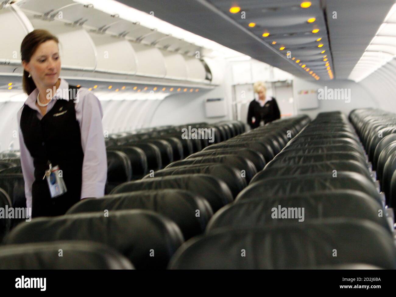Frontier Airlines flight attendant Cheryl Jacquot checks seats for safety  cards before a trip to Washington, DC at the Denver airport August 27,  2009. Frontier was acquired by Republic Airways in an