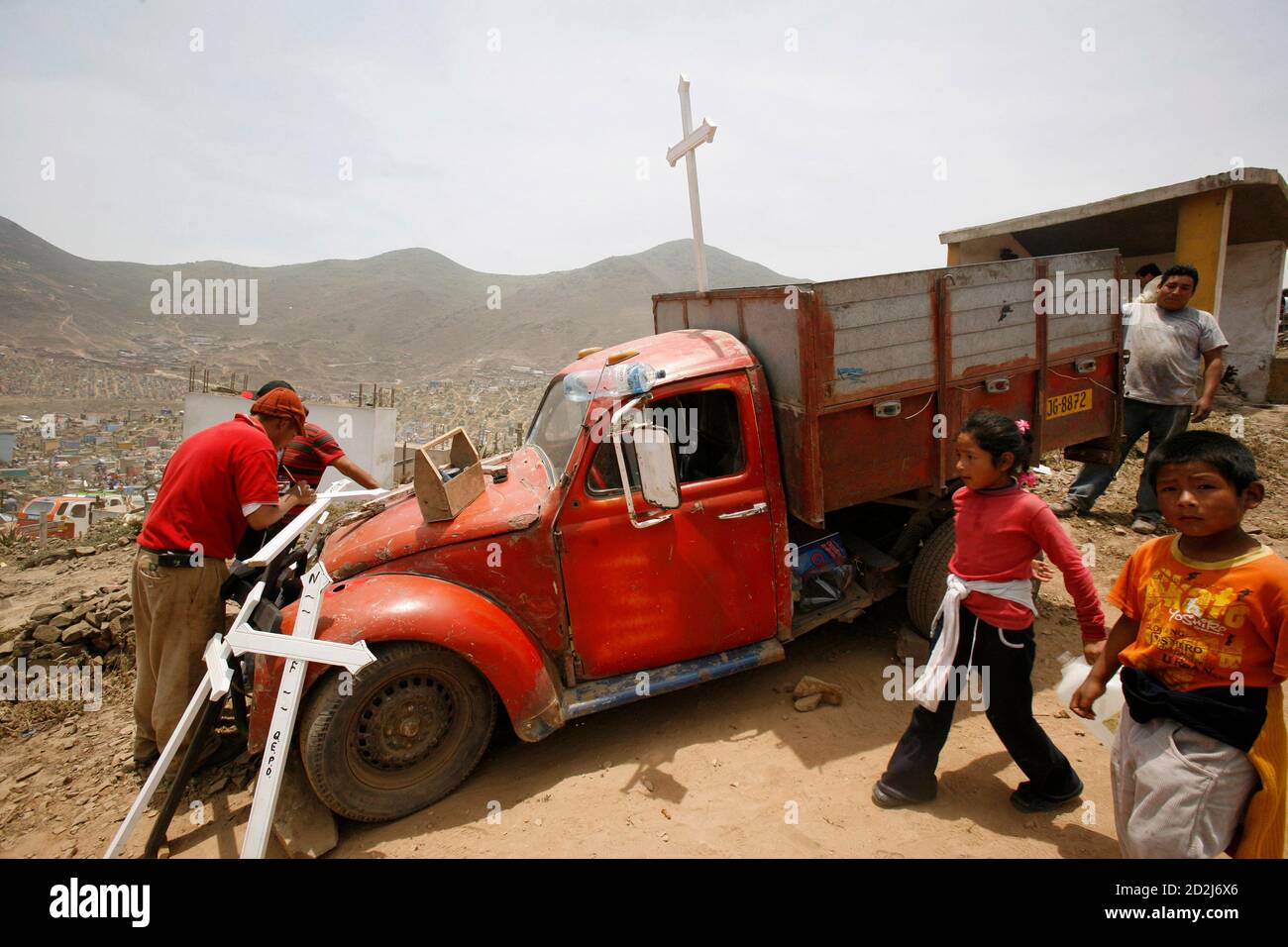 A man writes the names of the dead on crosses for a fee near a truck during 'Day of the Dead' celebrations in Nueva Esperanza cemetery on the outskirts of Lima November 1, 2009. Every year thousands of people visit cemeteries in Peru to honour their dead.  REUTERS/Mariana Bazo  (PERU SOCIETY) Stock Photo