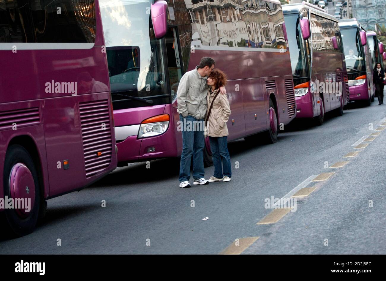 A Spanish couple hug while standing next to tourist buses that are stuck  during a 24-hour strike at the port of Piraeus, near Athens, April 26,  2010. Dockers at Greece's largest ports