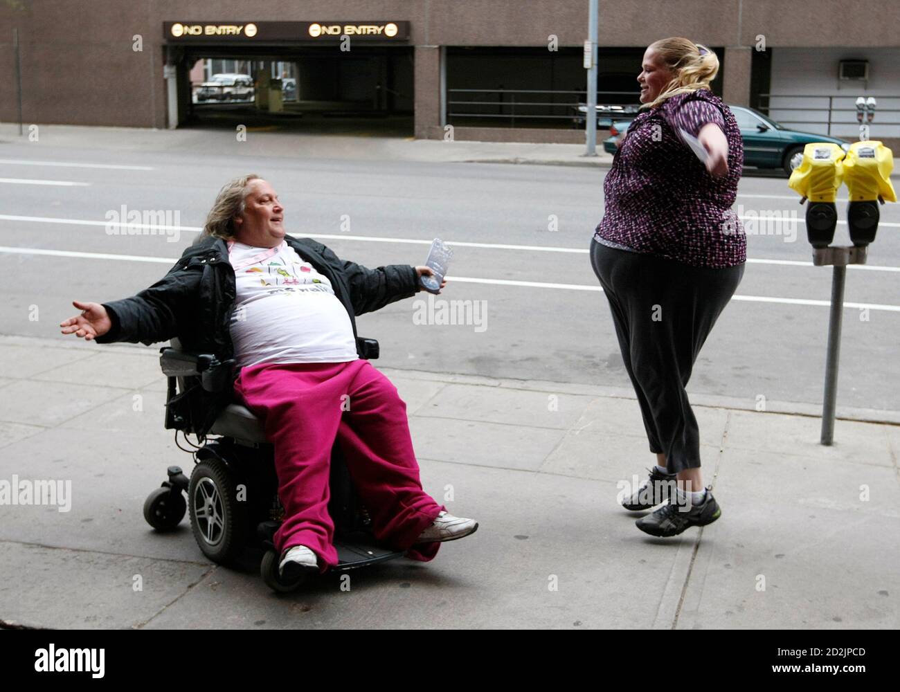 Gabi Jones does jumping jacks with her friend Pam while they wait for friends to join them for dinner outside a restaurant in Denver April 21, 2010. Jones (not her real name) is a an advocate for fat acceptance and speaks to schools on the topic. Picture taken April 21, 2010. REUTERS/Rick Wilking  (UNITED STATES - Tags: HEALTH SOCIETY) Stock Photo