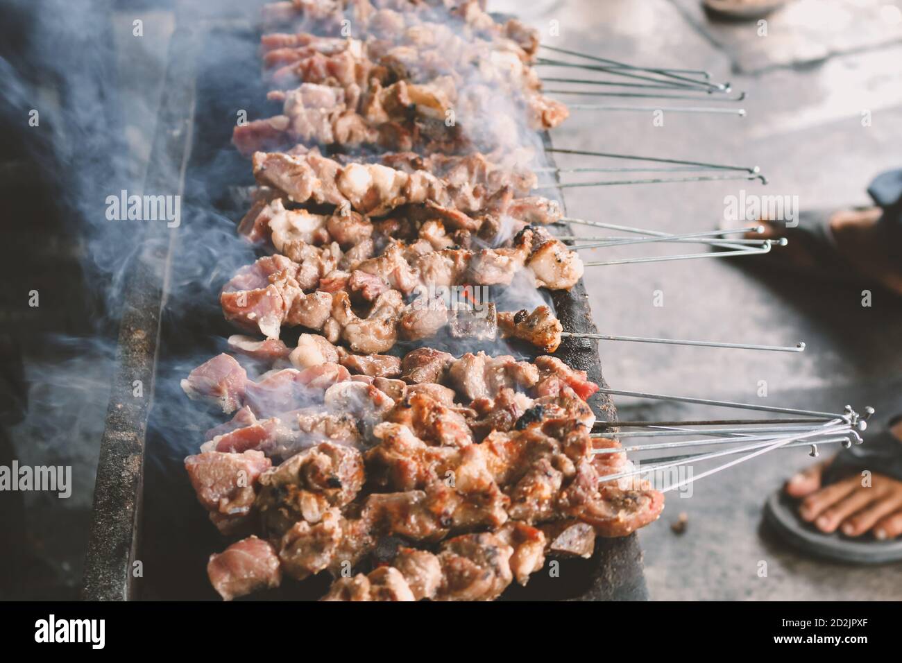 Sate Klatak grilling on charcoal grill. Sate klathak is a unique goat satay or mutton satay dish, originally from Yogyakarta, Indonesia. Stock Photo