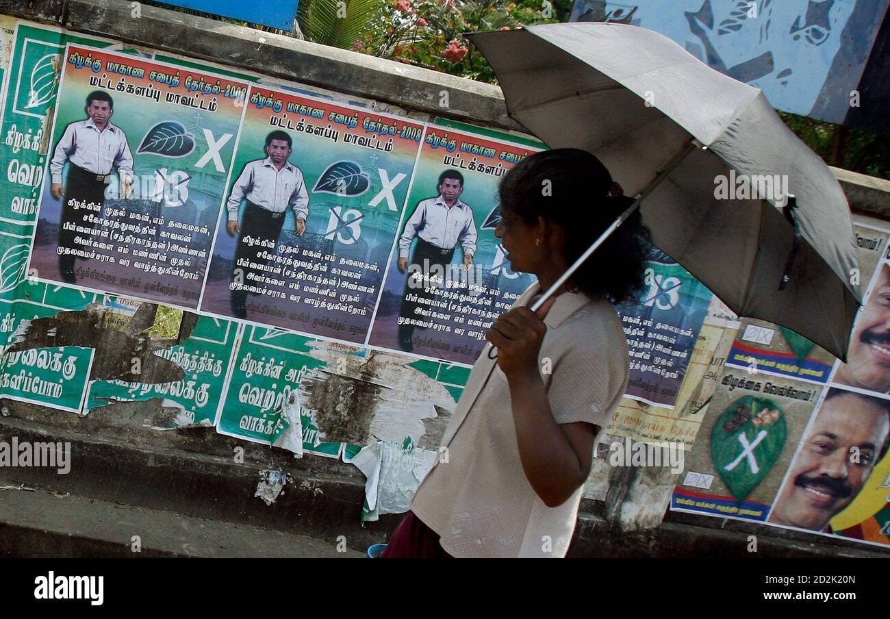 A woman reads political posters on a street on the last day of provincial  council election campaign in Batticaloa, in eastern Sri Lanka May 7, 2008.  REUTERS/Adnan Abidi (SRI LANKA Stock Photo -