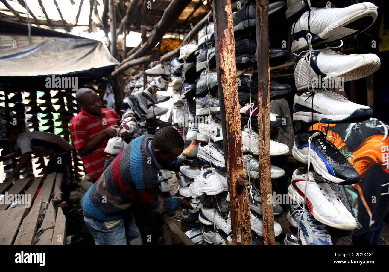 Customers choose second-hand shoes for sale at an open market in Kenya's capital Nairobi, April 3, 2009. The global economic slump makes it even more important for African governments to help local businesses by cutting red tape in areas like customs, tax and registration, a continental investment body said on Friday. REUTERS/Thomas Mukoya (KENYA BUSINESS POLITICS) Stock Photo