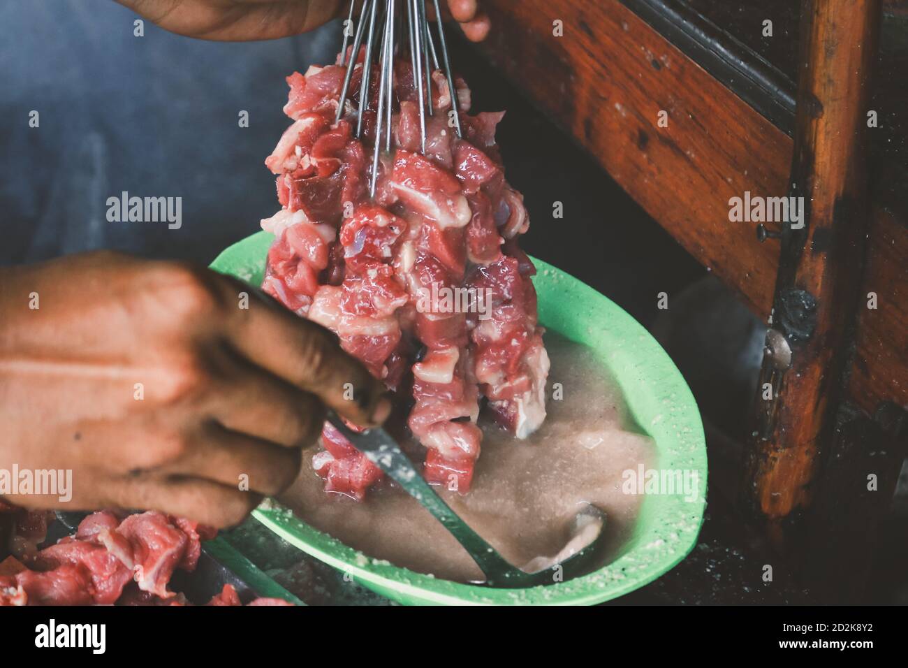 Giving curry to make goat satay, lamb satay, lamb or meat goat satay with raw meat. Sate Klatak Traditional satay from Yogyakarta, Indonesia. Stock Photo