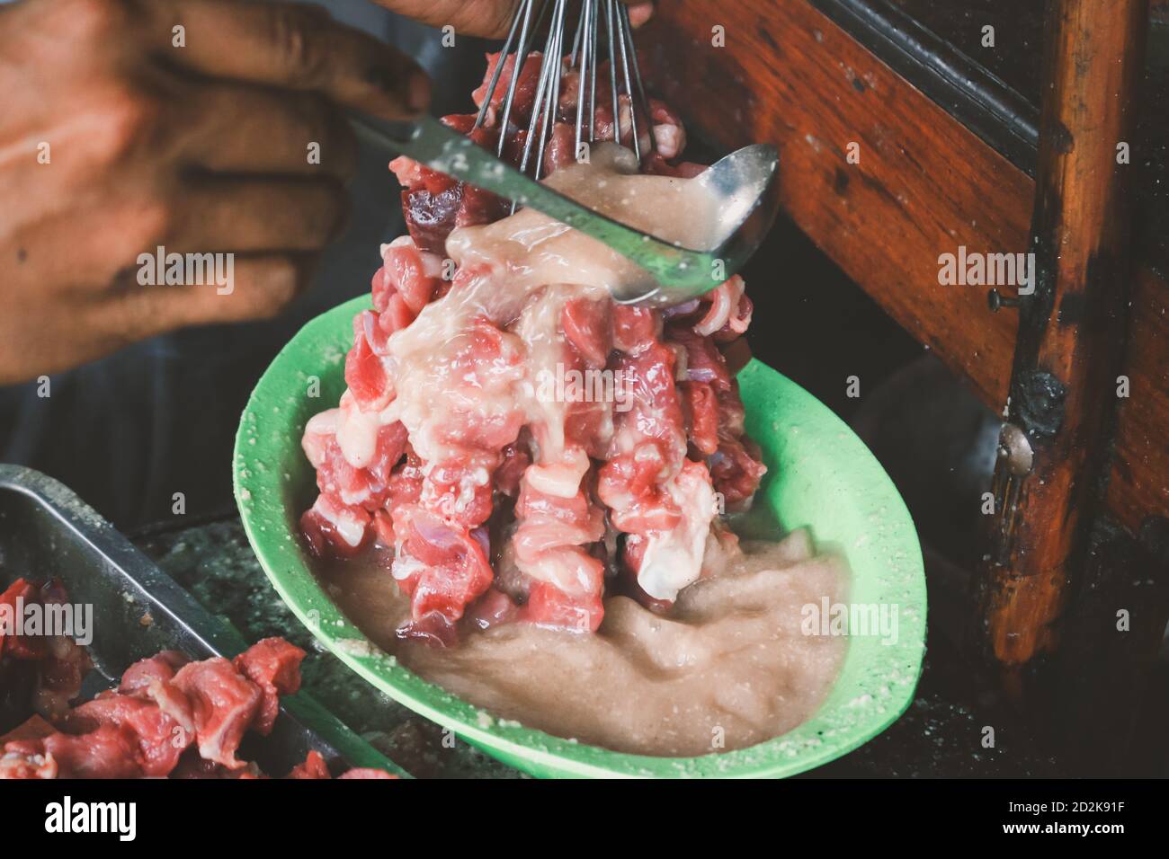 Giving curry to make goat satay, lamb satay, lamb or meat goat satay with raw meat. Sate Klatak Traditional satay from Yogyakarta, Indonesia. Stock Photo