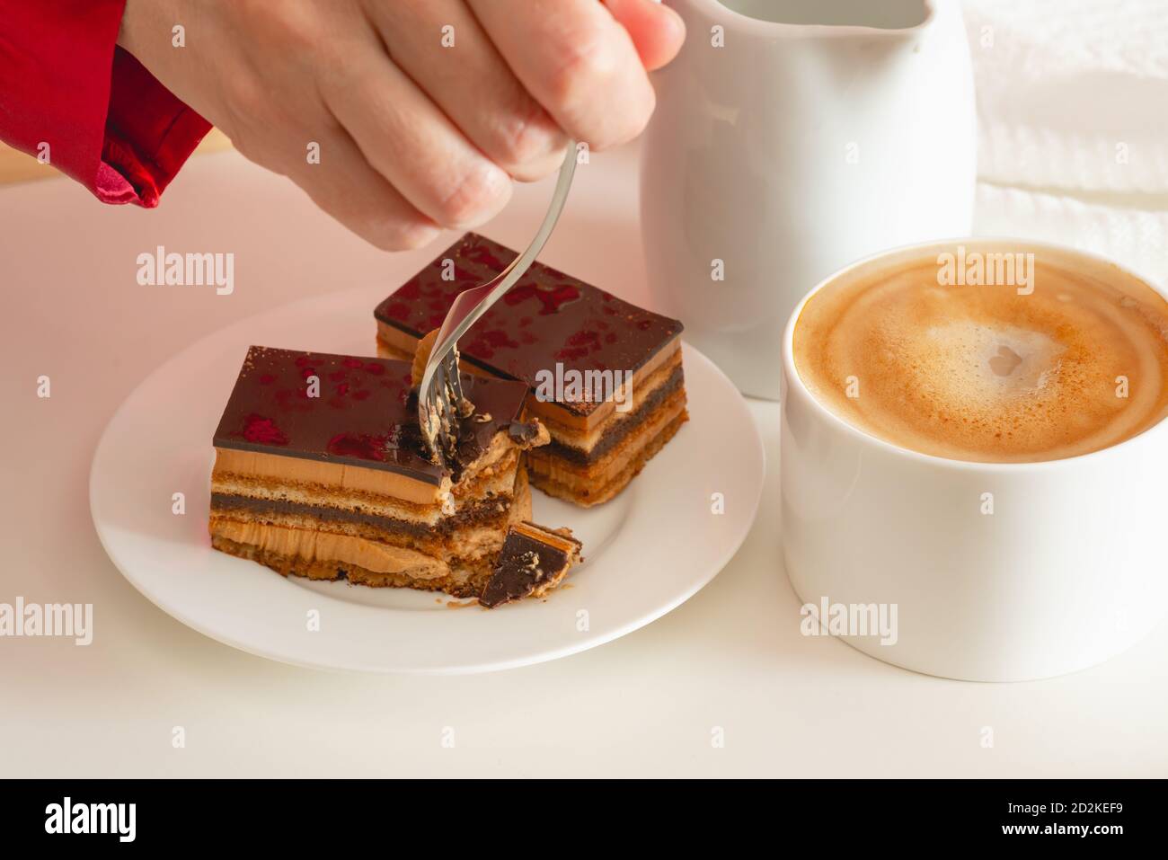 Cup of coffee with milk, and chocolate cake. Sweet delicious breakfast on a bed tray table Stock Photo