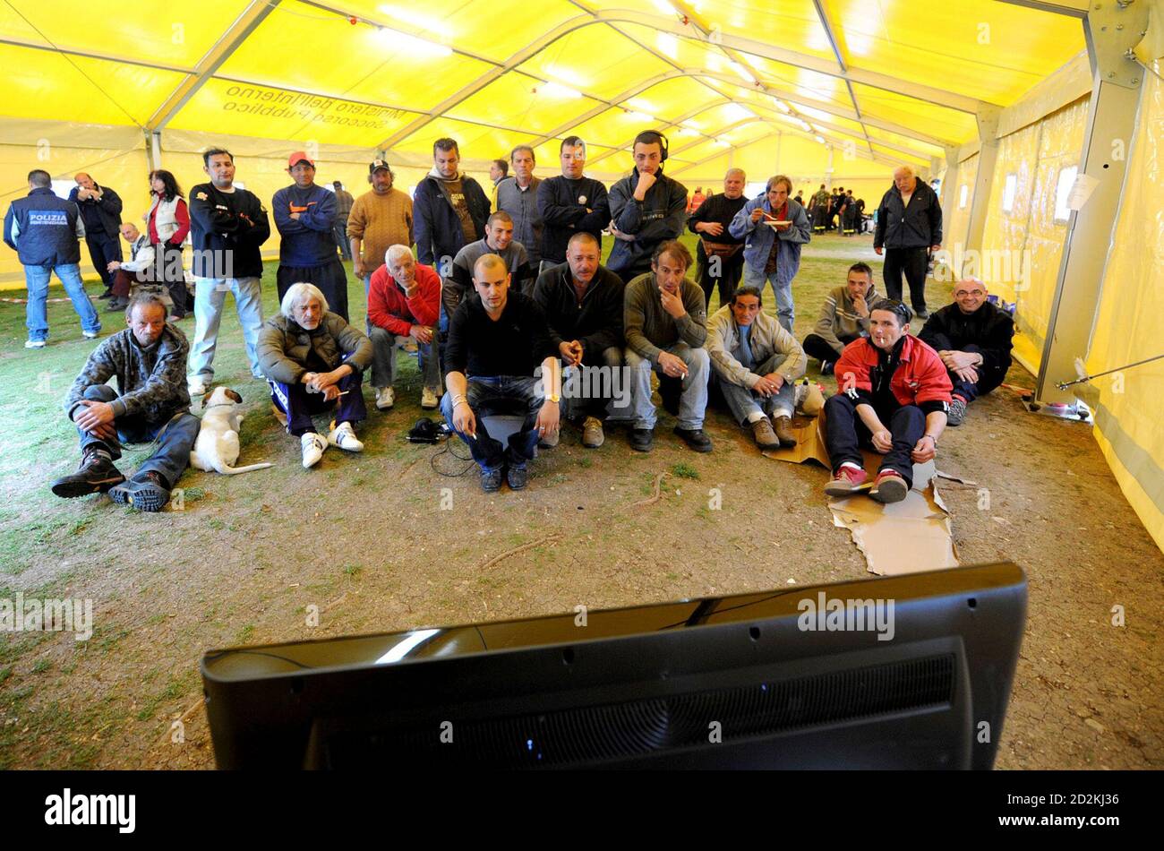People who lost their homes in an earthquake watch Italian Serie A soccer matches on satellite television at a camp in L'Aquila April 11, 2009.  REUTERS/Daniele La Monaca     (ITALY DISASTER SPORT SOCCER) Stock Photo