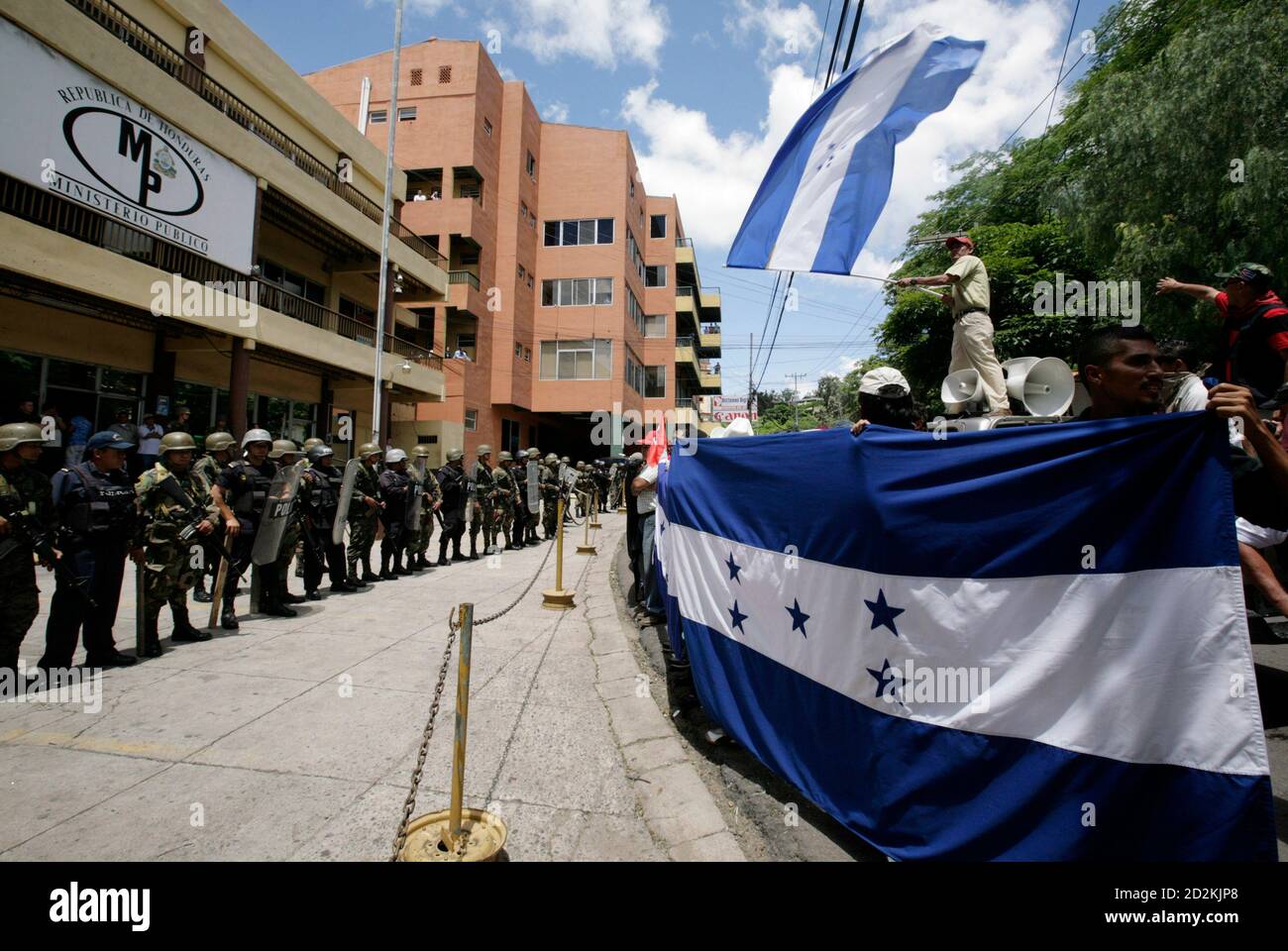 Supporters (R) of Honduras' ousted President Manuel Zelaya protest in front of the Public Ministry building in Tegucigalpa July 7, 2009. Ousted Honduran President Manuel Zelaya said on Tuesday he accepted the mediation of Costa Rican President Oscar Arias to try to solve his country's political crisis following the June 28 coup that ousted him. REUTERS/Oswaldo Rivas (HONDURAS POLITICS CONFLICT MILITARY) Stock Photo