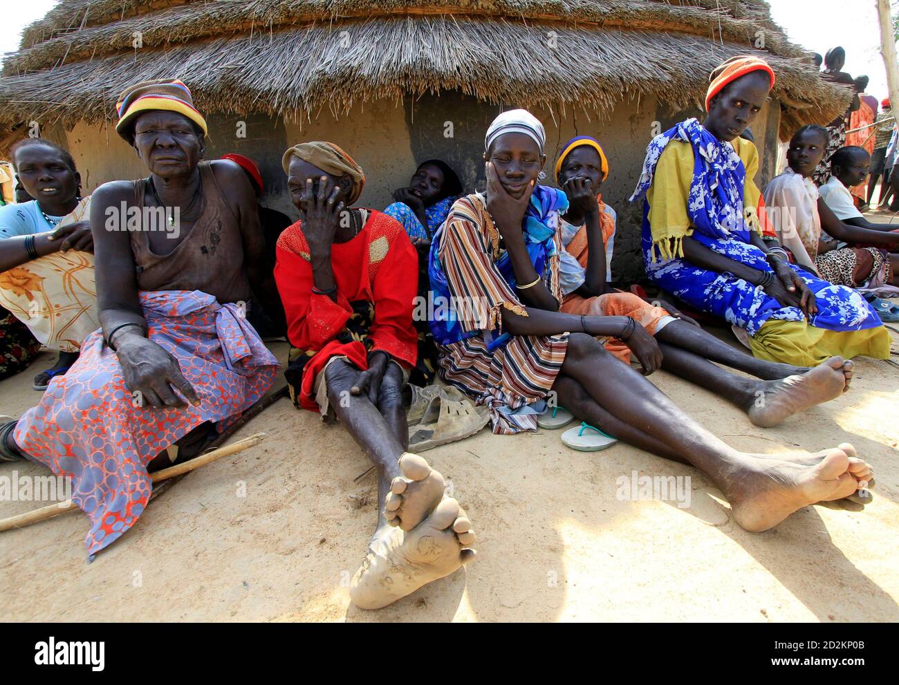 Members of Sudan-born NBA star Manute Bol's family wait outside a hut for  the arrival of Bol's body in the town of Turalei in Warap state, southern  Sudan July 4, 2010. Bol