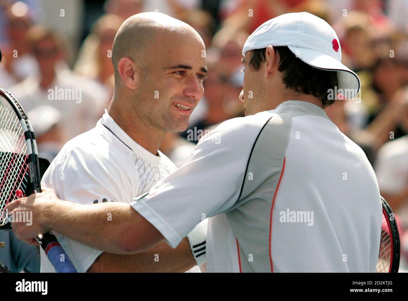 Andre Agassi (L) of the U.S. congratulates Germany's Benjamin Becker on his  win at the U.S. Open tennis tournament in New York September 3, 2006. Agassi  was playing in his last U.S.