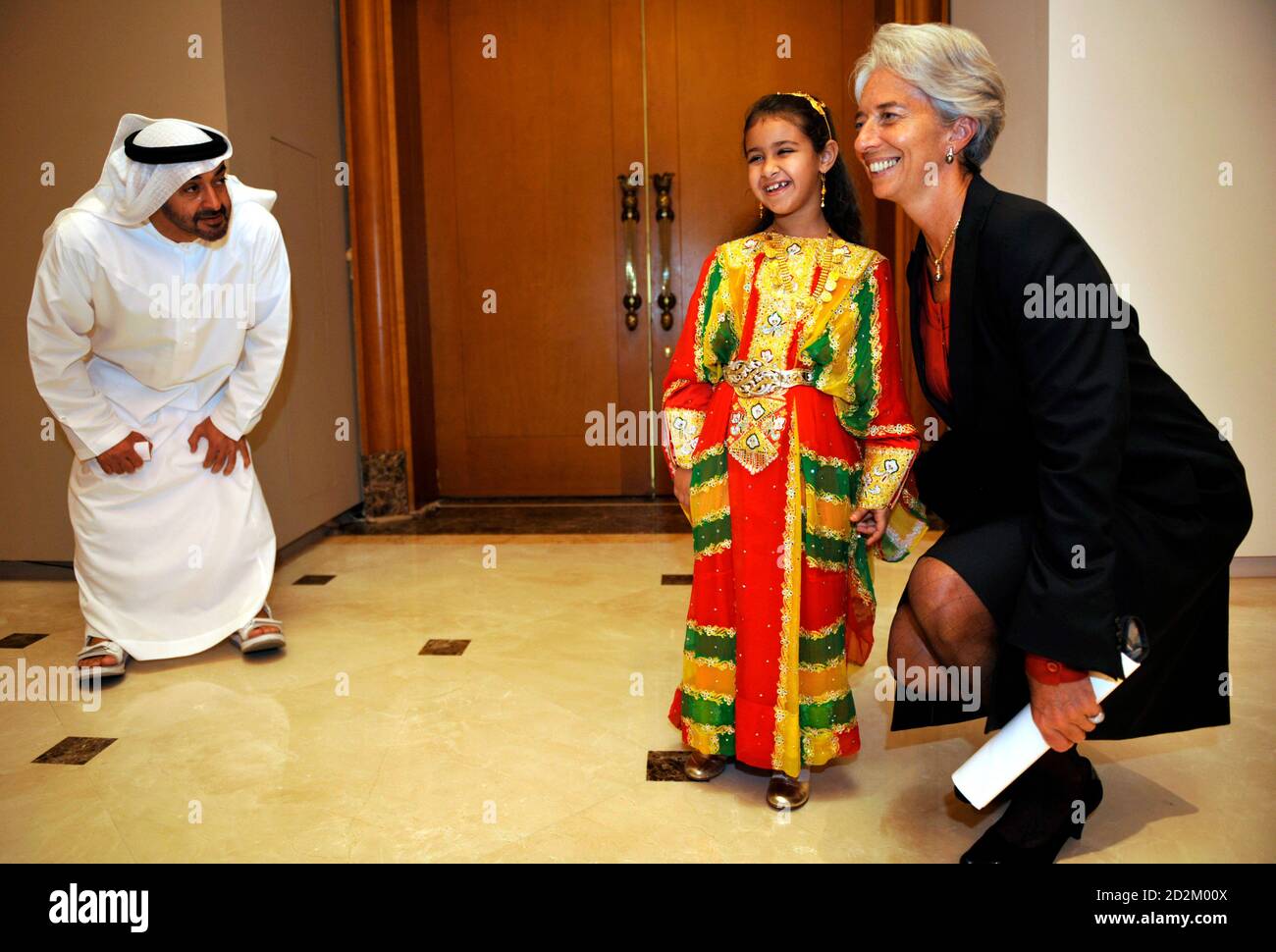 Abu Dhabi Crown Prince Sheikh Mohammed Bin Zayed Al Nahyan encourages his  daughter Princess Hassa (C) as she poses for photographers with France's  Finance Minister Christine Lagarde at a cultural exhibition in