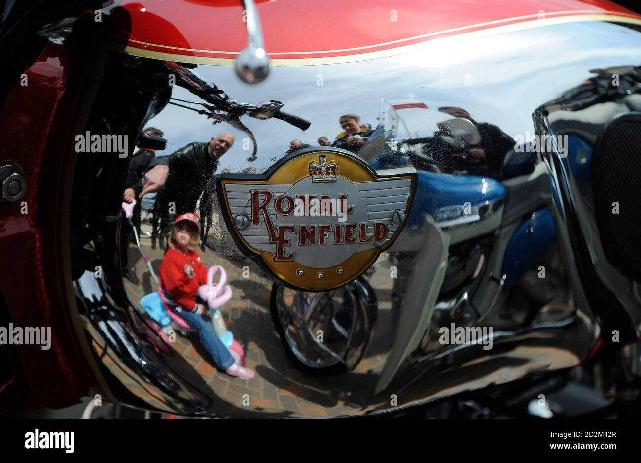 People are reflected in a motorcycle fuel tank during 'Mad Sunday' at the TT meeting, on the Isle of Man June 7, 2009.       REUTERS/Nigel Roddis      (BRITAIN SPORT MOTOR RACING SOCIETY) Stock Photo