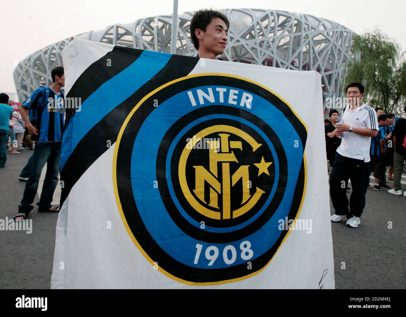 An Inter Milan fan holds a flag with the club emblem ahead of the Italian  Super Cup soccer match between Inter Milan and Lazio at the National  Olympic Stadium, also known as
