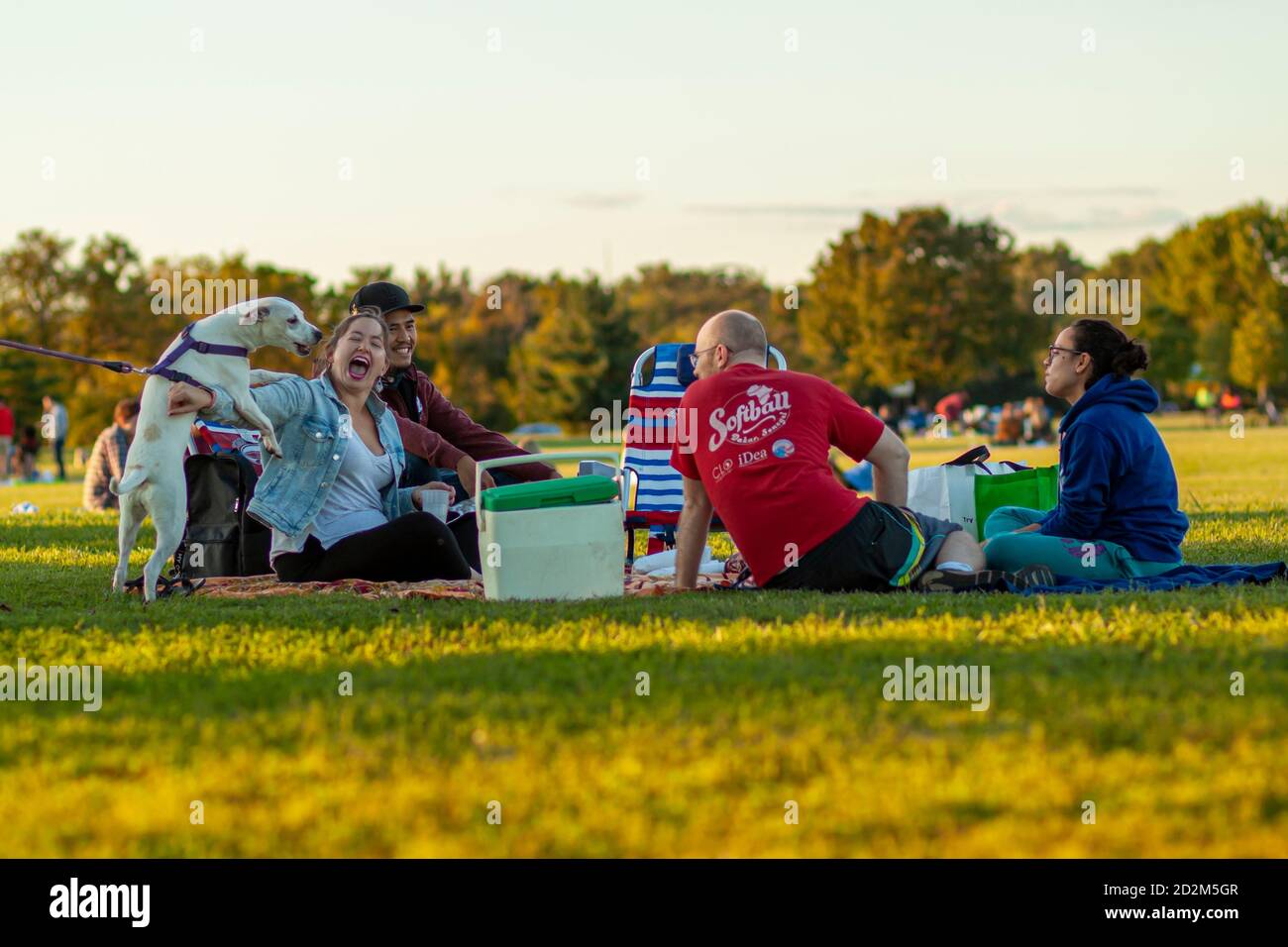 Arlington, VA, USA 10/02/2020: A multi racial group of young people are sitting on foldable chairs or sheets on grass field of Gravelly point park. Th Stock Photo