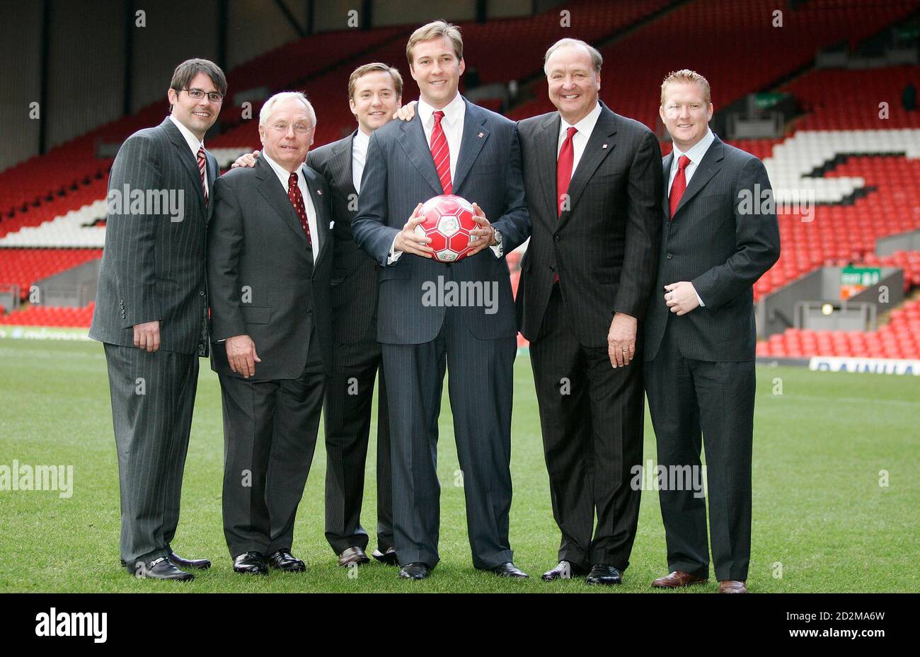 Liverpool Football Club's new owners George Gillett (2nd L) and Tom Hicks  (2nd R) pose for photographers with their family members in front of the  club's Kop stand at Anfield in Liverpool,