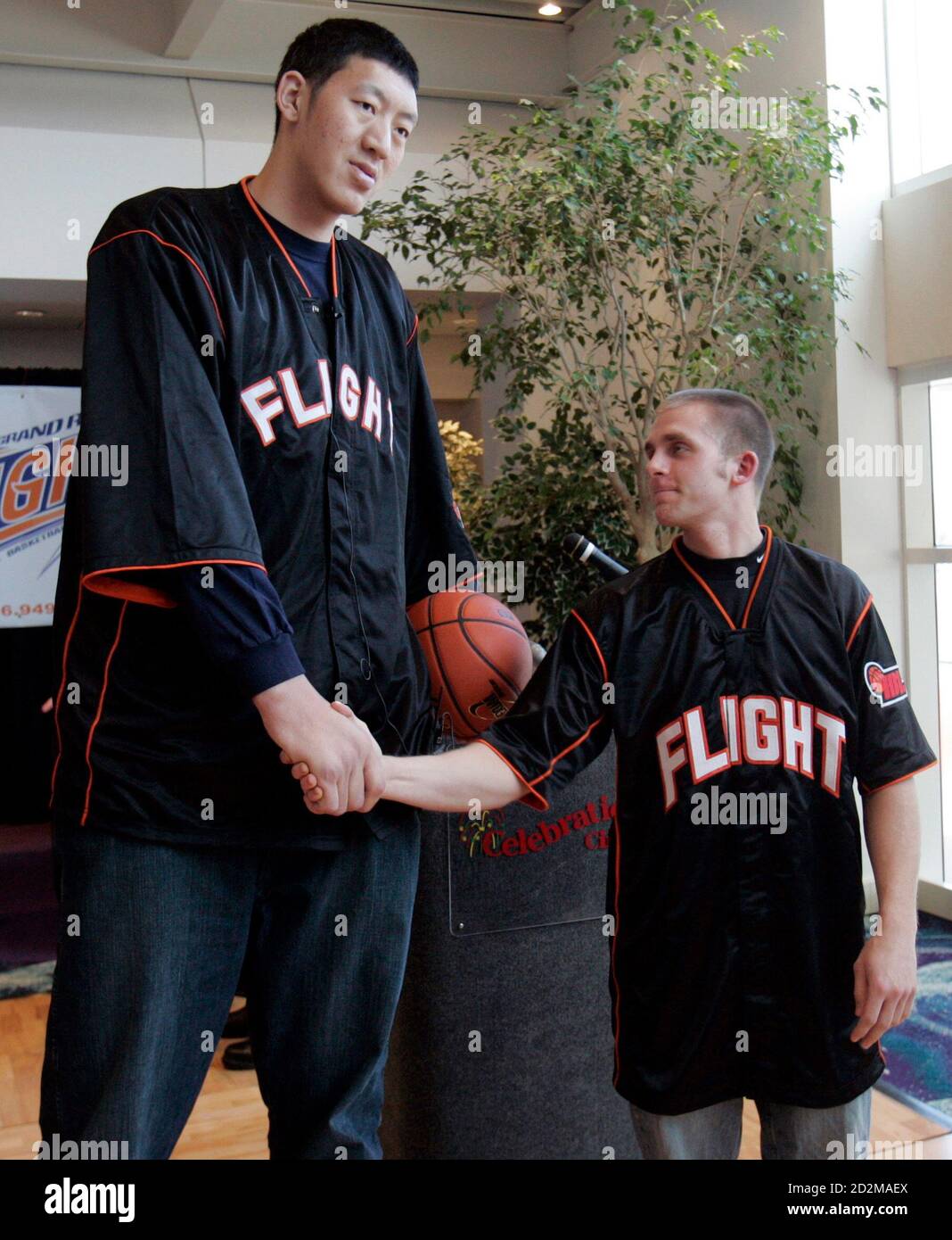 Grand Rapids Flight's seven feet, nine inches (2.36 metres) tall basketball  player Sun Ming Ming (L) from China shakes hands with teammate, five feet,  nine inches (1.75 metres) tall Micah Lancaster at
