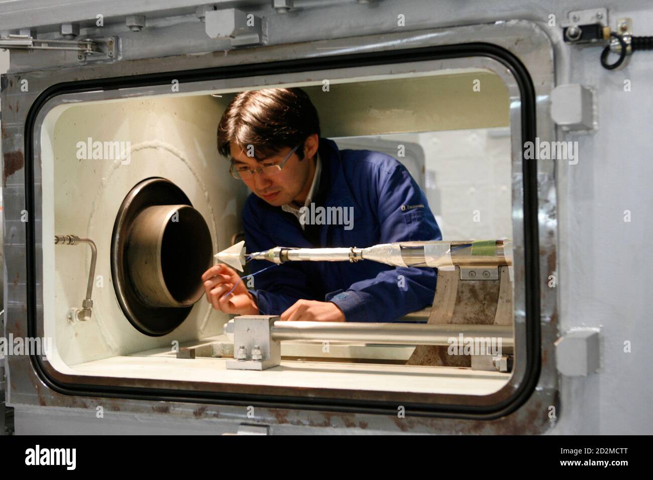 University of Tokyo research associate in aerospace engineering Osamu  Imamura handles an origami airplane test model before a test in a wind  tunnel at a Tokyo University research facility in Kashiwa, Japan