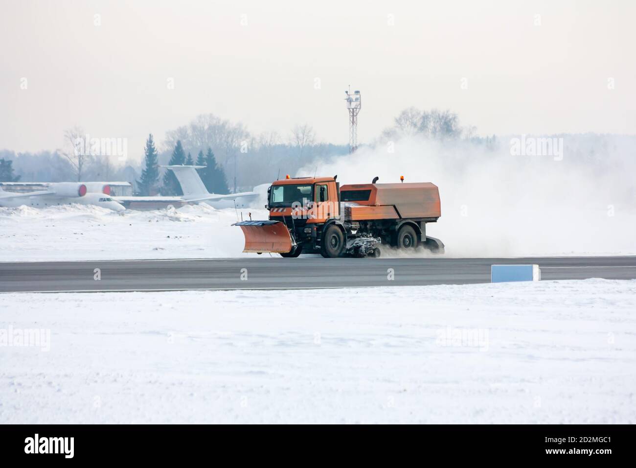Snowremoval machine cleans the main taxiway at the airport Stock Photo