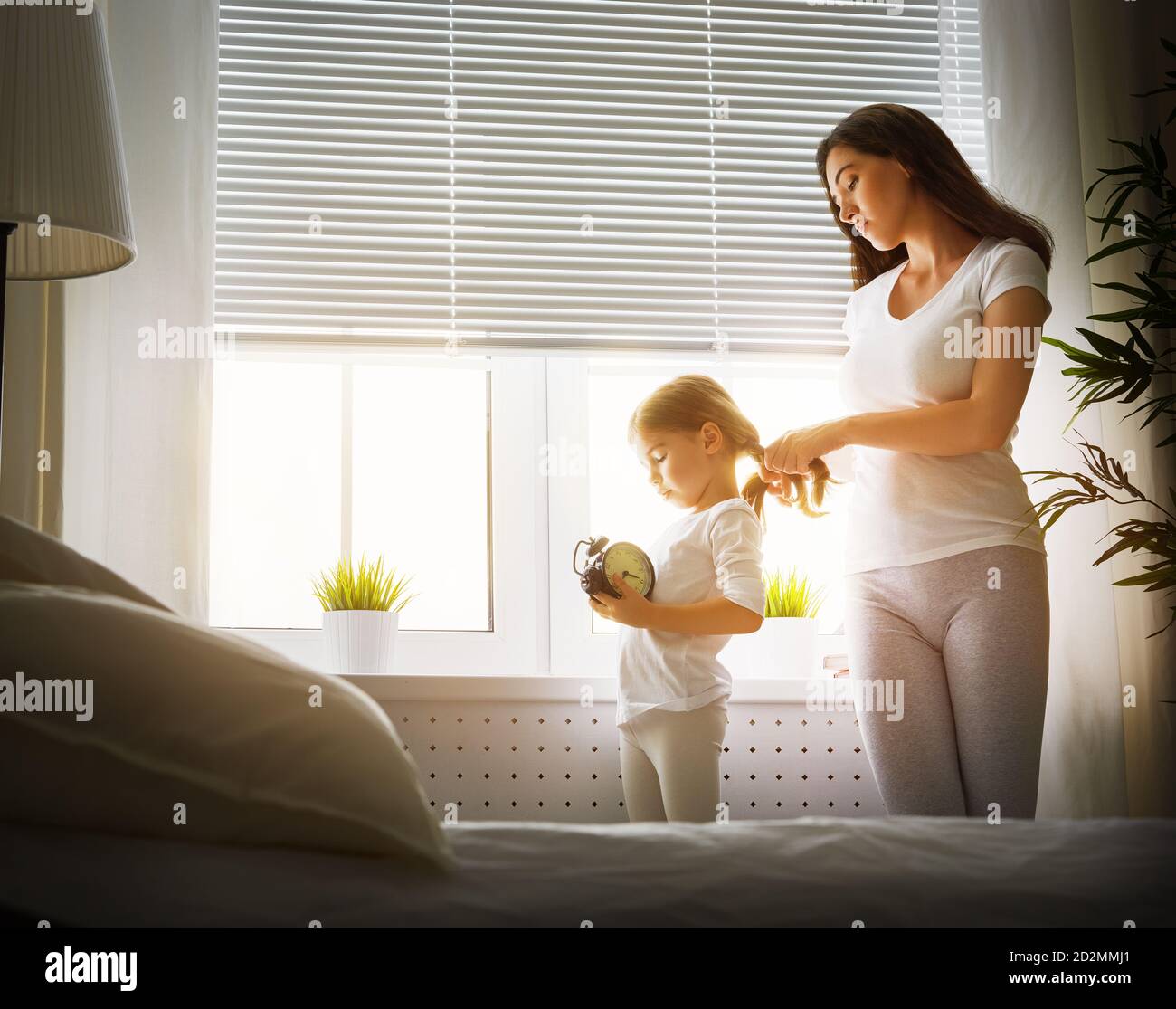 mother combing her daughter's hair Stock Photo