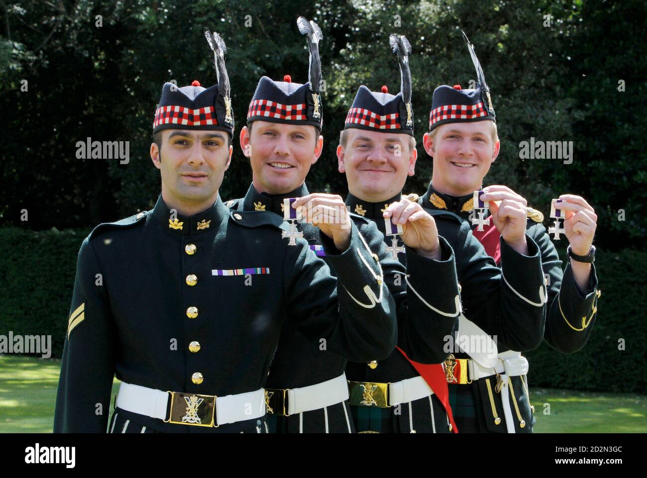British soldiers (L-R) Corporal Christopher Reynolds, Corporal Craig Sharp, Corporal Richard Clark and Captain Alexander Phillips from The Royal Regiment of Scotland pose for photographers with their Military Cross medals after a presentation by the Queen at Holyrood Palace in Edinburgh, Scotland 13 July, 2010. REUTERS/David Moir (BRITAIN - Tags: CONFLICT POLITICS SOCIETY) Stock Photo