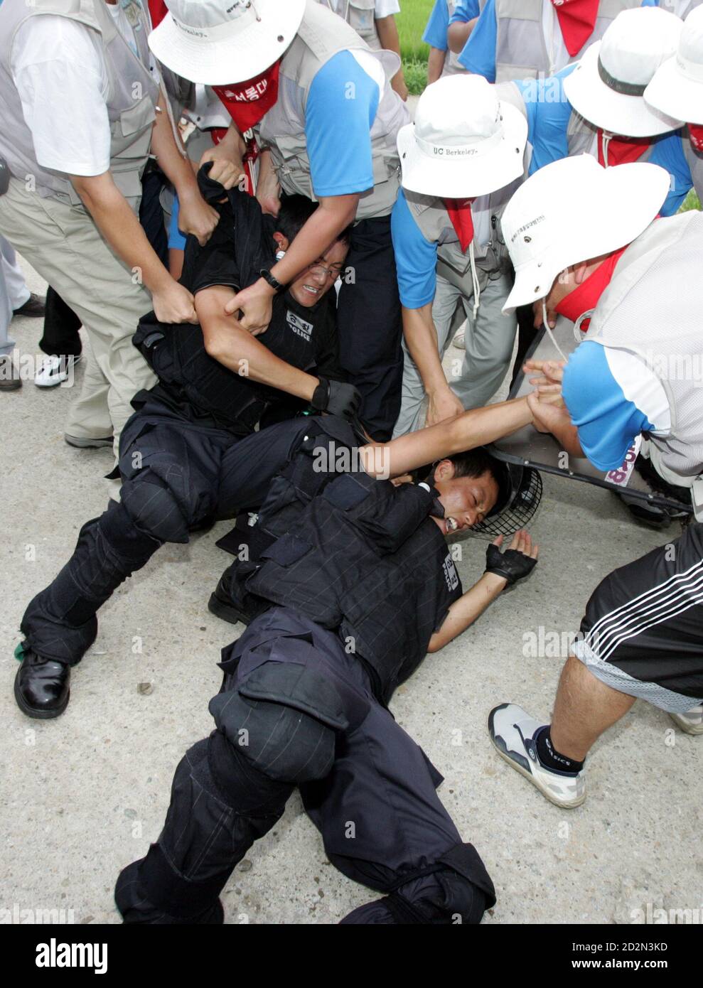 Protesters detain two riot policemen as police use shields and clubs to stop protesters trying to enter U.S. army's Camp Humphreys in Pyongtaek, South Korea. Protesters detain two riot policemen as police use shields and clubs to stop the protesters trying to enter the U.S. army's Camp Humphreys in Pyongtaek, about 80 km (50 miles) south of Seoul, August 8, 2005. About 500 South Korean protesters from labour unions and college students' groups rallied near the U.S. army base on Monday as they demanded U.S. forces leave the country, which they insist block the reunification of the two Koreas. Stock Photo
