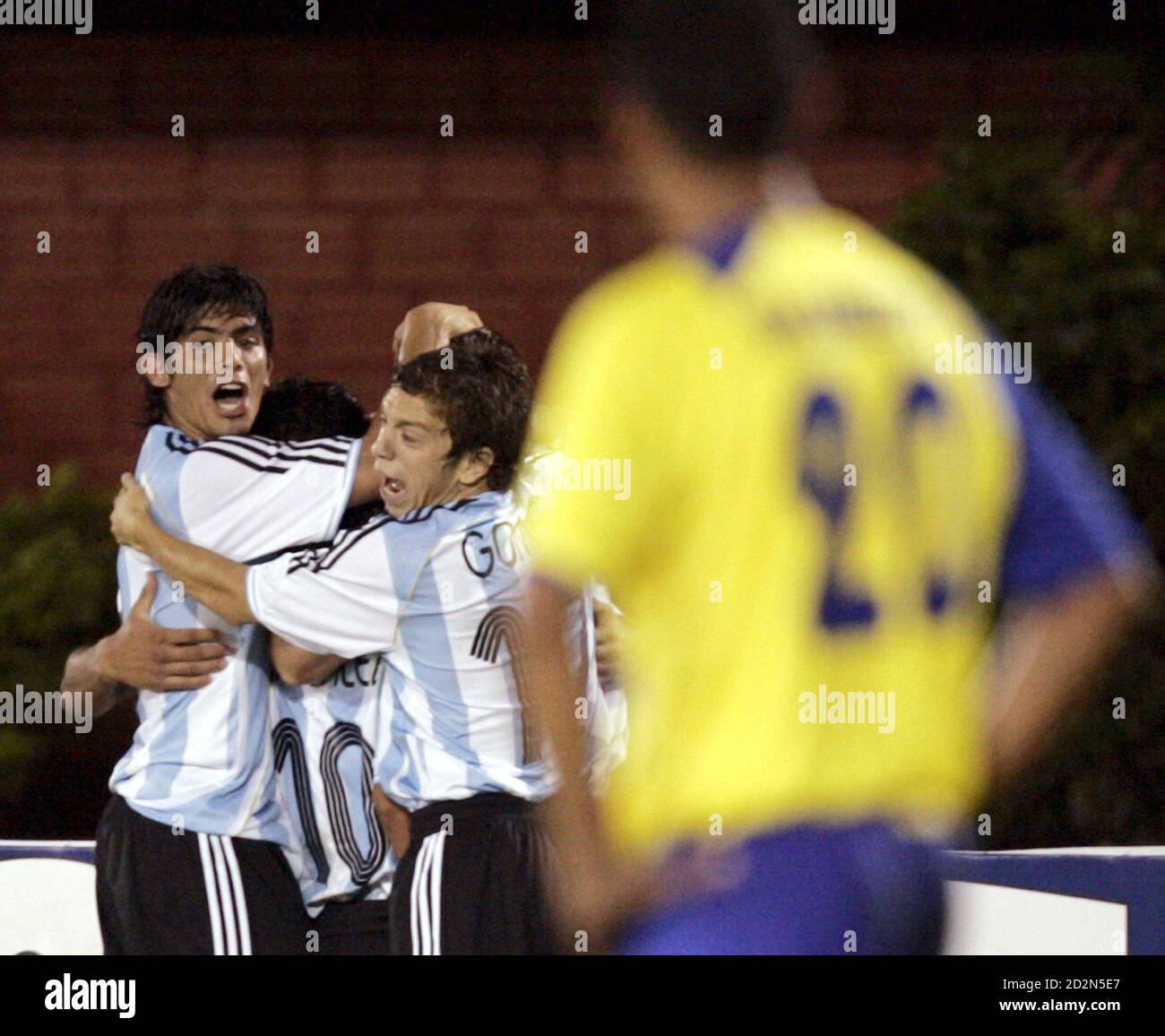 Argentina's Ever Banega (L), Maximiliano Moralez (10) and Alejandro Gomez  (R) embrace team mate Gonzalo Aban after he scored a goal, while Ecuador's  Victor Valarezo (front) watches, during their Group B soccer