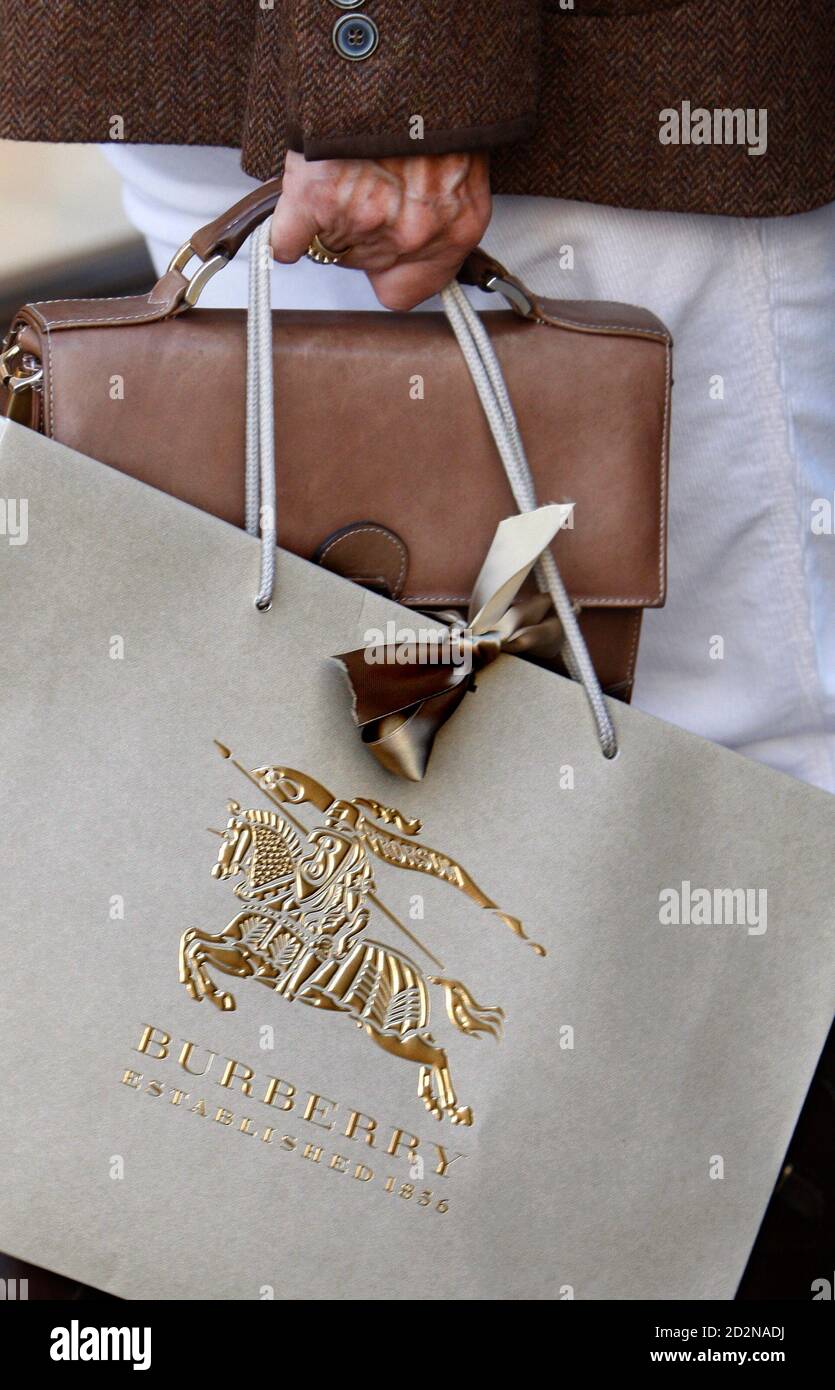 A customer carries a Burberry shopping bag in London, October 11, 2008.  Luxury goods group Burberry beat forecasts with a 13 percent rise in  first-half underlying revenue, but said trading conditions were