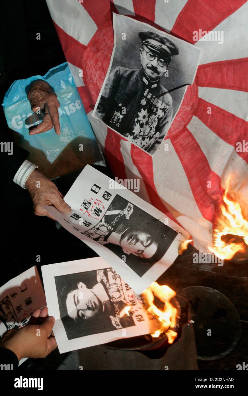 Protesters Burn A Japanese Military Flag Featuring A Photo Of Hideki Tojo Top A General In The Imperial Japanese Army And Prime Minister Of Japan During World War Ii And Hirohito The
