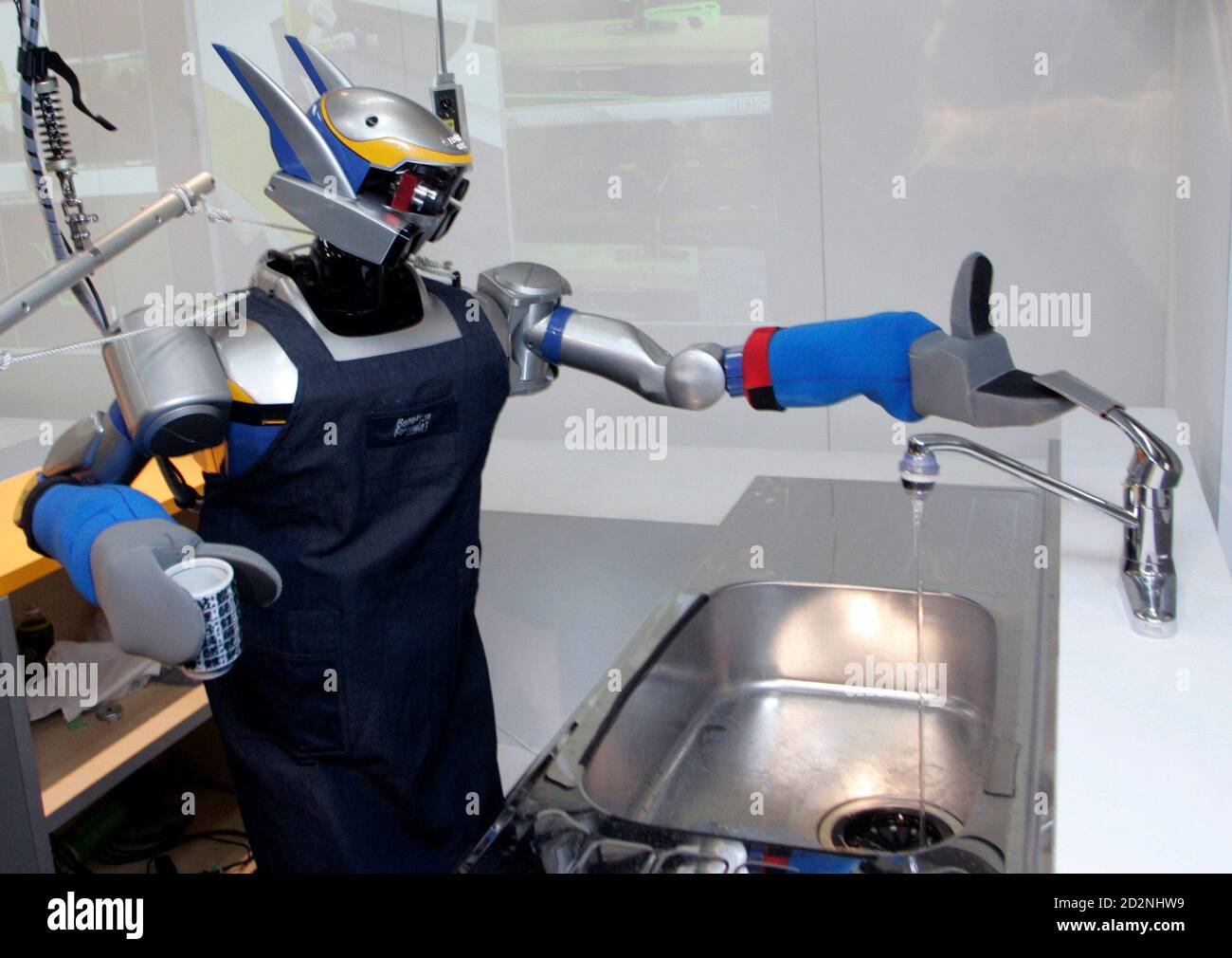 Humanoid robot HRP-2 uses a tap after washing a cup during a demonstration  at Tokyo University in this February 28, 2007 picture. A Japanese  university has developed two humanoid bartender and waiter