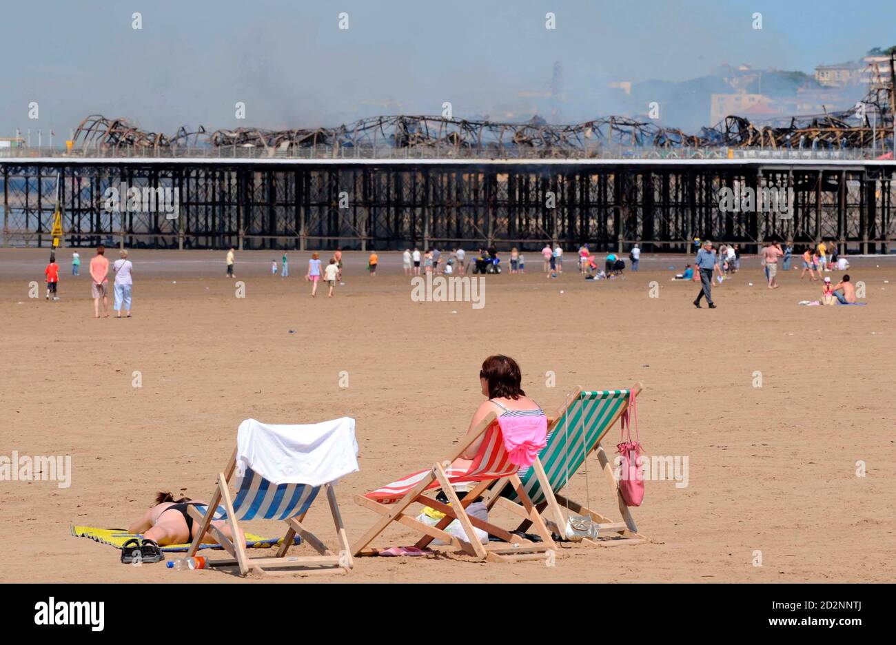 Holiday makers look at the Grand Pier at Weston-Super-Mare in south west England July 28, 2008. Firefighters were called to a large blaze that swept through the historic pier at the Somerset seaside resort of Weston-super-Mare on Monday, police said. Flames and thick black smoke engulfed the structure and could be seen from the M5 motorway, several miles from the coast, a fire brigade spokeswoman said. REUTERS/Toby Melville (BRITAIN) Stock Photo