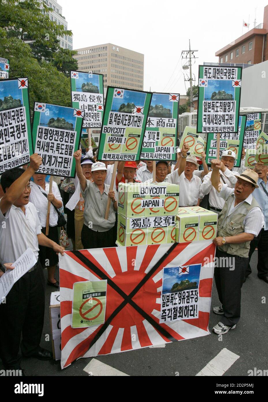 Protesters chant slogans in front of signs representing Japan's middle school teaching guide at a demonstration against Japan's sovereignty claim over a group of desolate volcanic islets Seoul and Pyongyang call Dokdo and Tokyo calls Takeshima, in front of Japanese embassy in Seoul July 15, 2008. South Korea's coastguard said on Tuesday it had stepped up patrols near the islands, a day after Seoul recalled its ambassador in anger at new Japanese claims to the rocky outcrops. On Monday, Tokyo said it had told Seoul that it would refer in a middle school teaching guide to the islands as Japanese Stock Photo