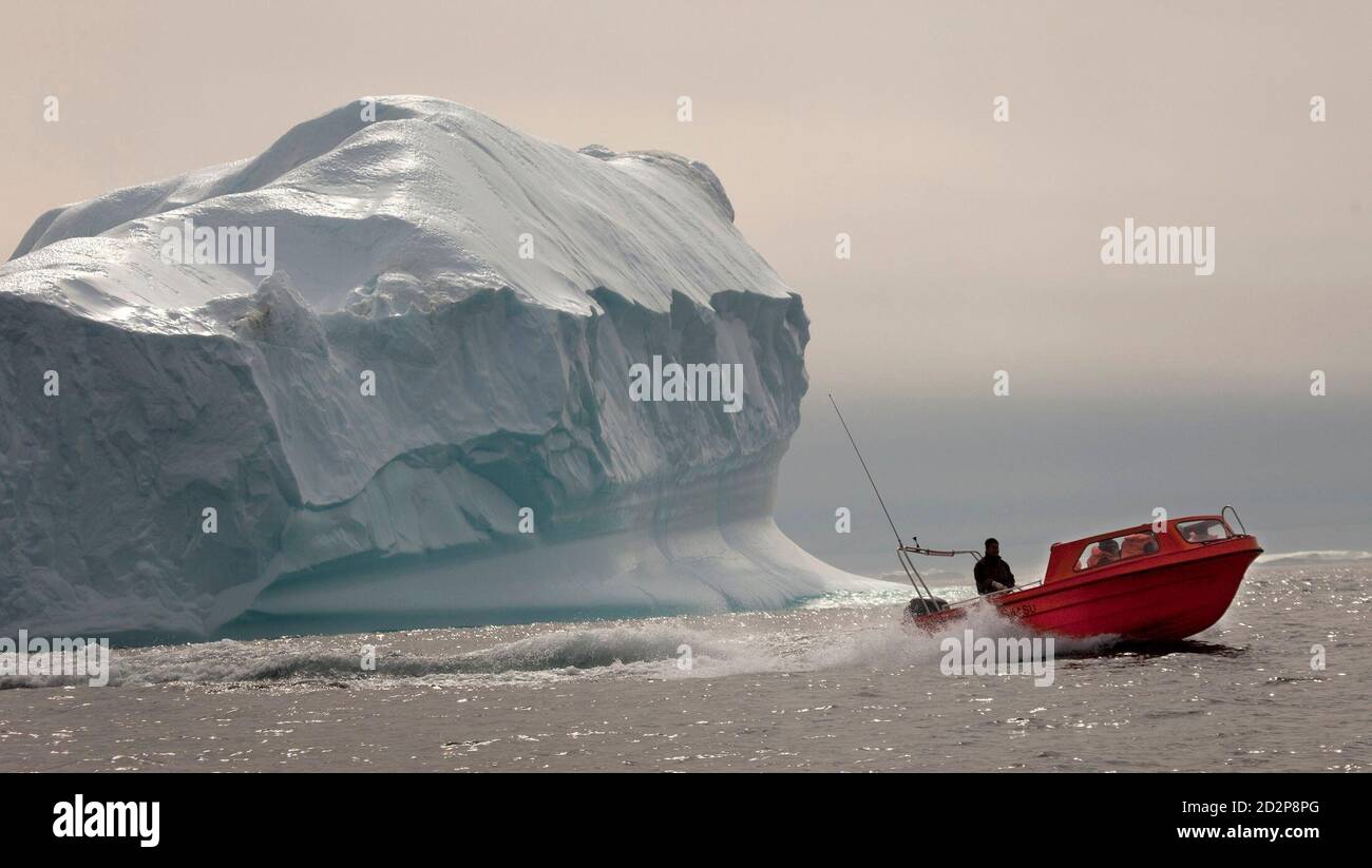 A carrying tourists speeds past an iceberg south of in eastern Greenland 2009. REUTERS/Bob Strong (GREENLAND Stock Photo - Alamy