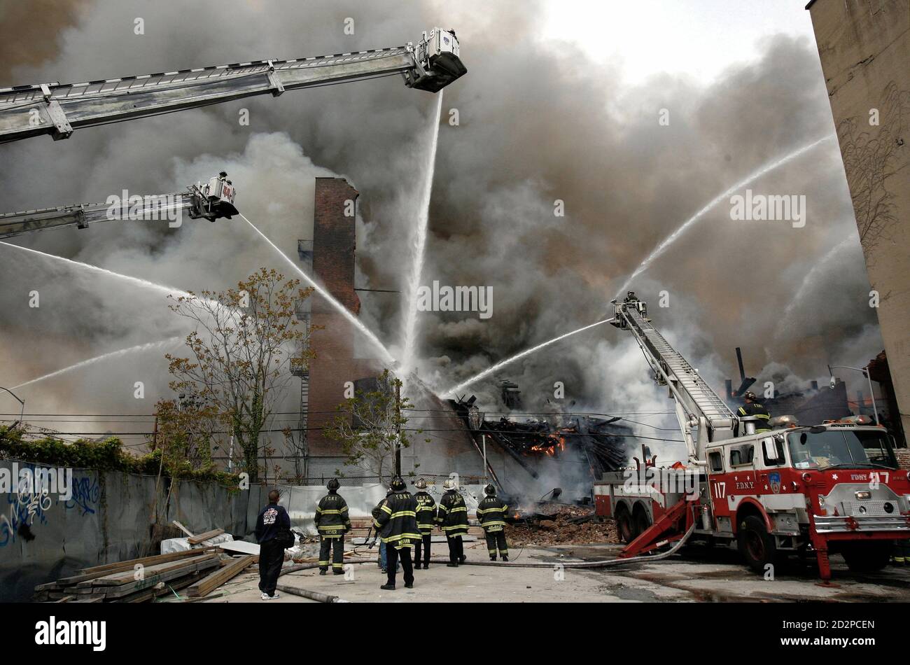 New York City firefighters battle a waterfront warehouse fire in Brooklyn, New York, May 2, 2006. The blaze, which had reached nine-alarm status and engulfed several buildings and wharfs along the East River, could be seen for miles. [Fire Commissioner Nicholas Scoppetta called it the largest fire in the city in more than a decade, excluding the World Trade Center attack.] Stock Photo
