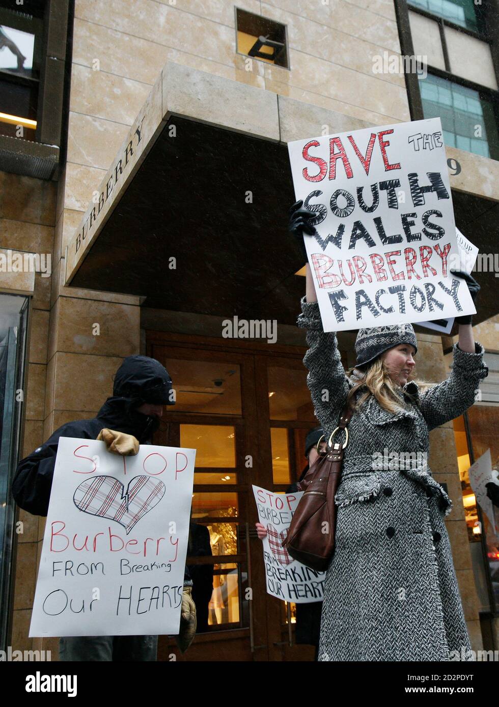 Protesters march the move of Burberry manufacturing, in front of a store in New York February 14, 2007. Shoppers at luxury group Burberry faced picketing its stores in Europe