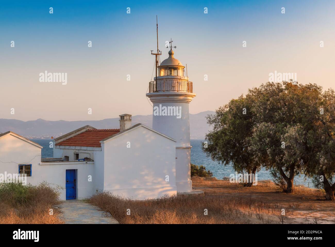Lighthouse on Aegean sea at sunset Stock Photo