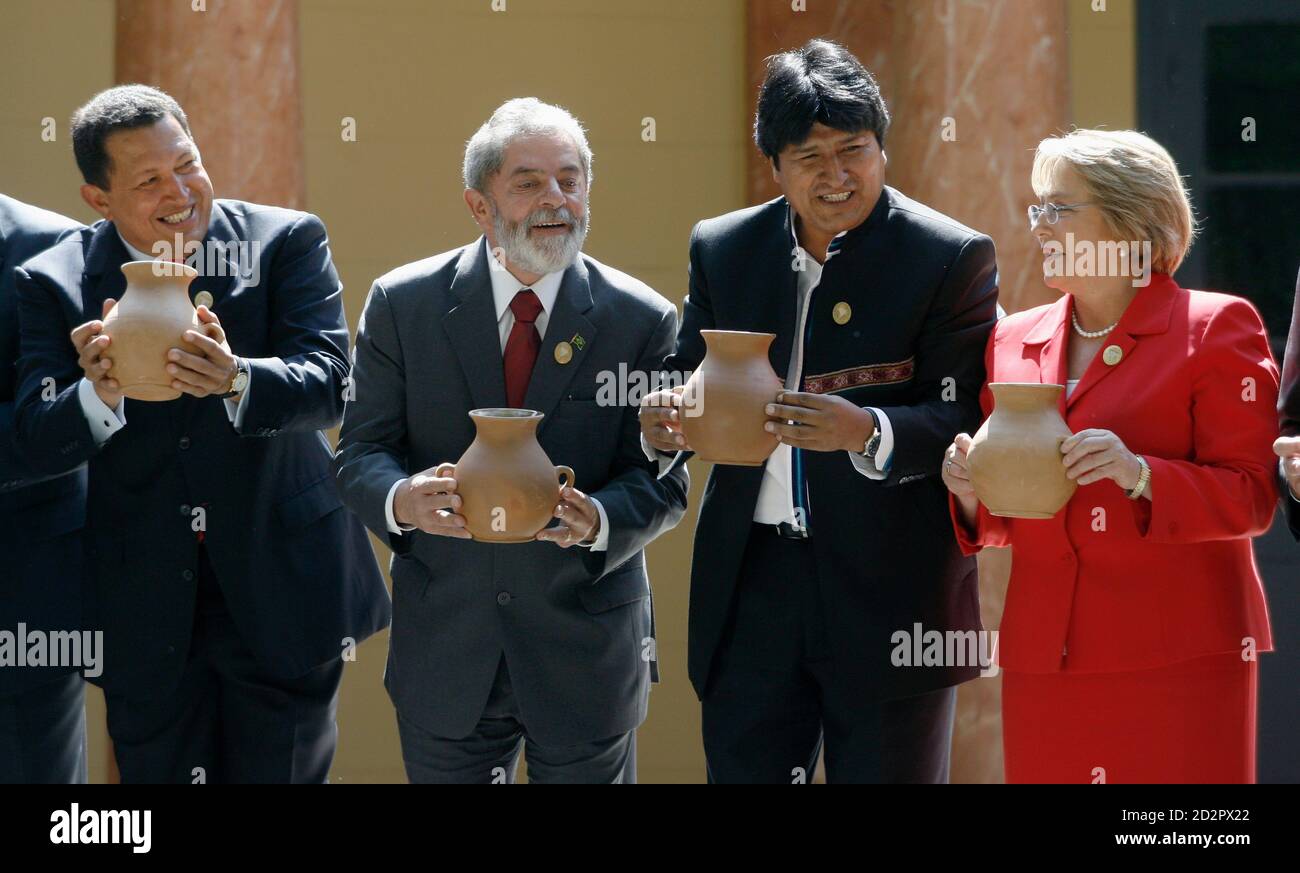 President of Venezuela Hugo Chavez, President of Brazil Luiz Inacio Lula Da Silva, President of Bolivia Evo Morales and President of Chile Michelle Bachelet hold clay jars containing 'chicha', an alcoholic beverage preferred by indigenous peoples, during an official photo session at the South American Community of Nations summit in Cochabamba December 9, 2006.   REUTERS/David Mercado  (BOLIVIA) Stock Photo