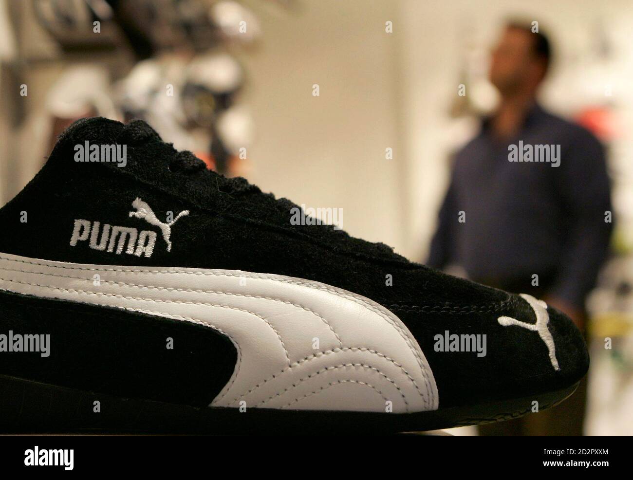 A customer looks at some shoes in the Puma factory outlet store in  Herzogenaurach near Nuremberg April 10, 2007. French retailer PPR on  Tuesday made a 5.3 billion euro ($7.07 billion) bid